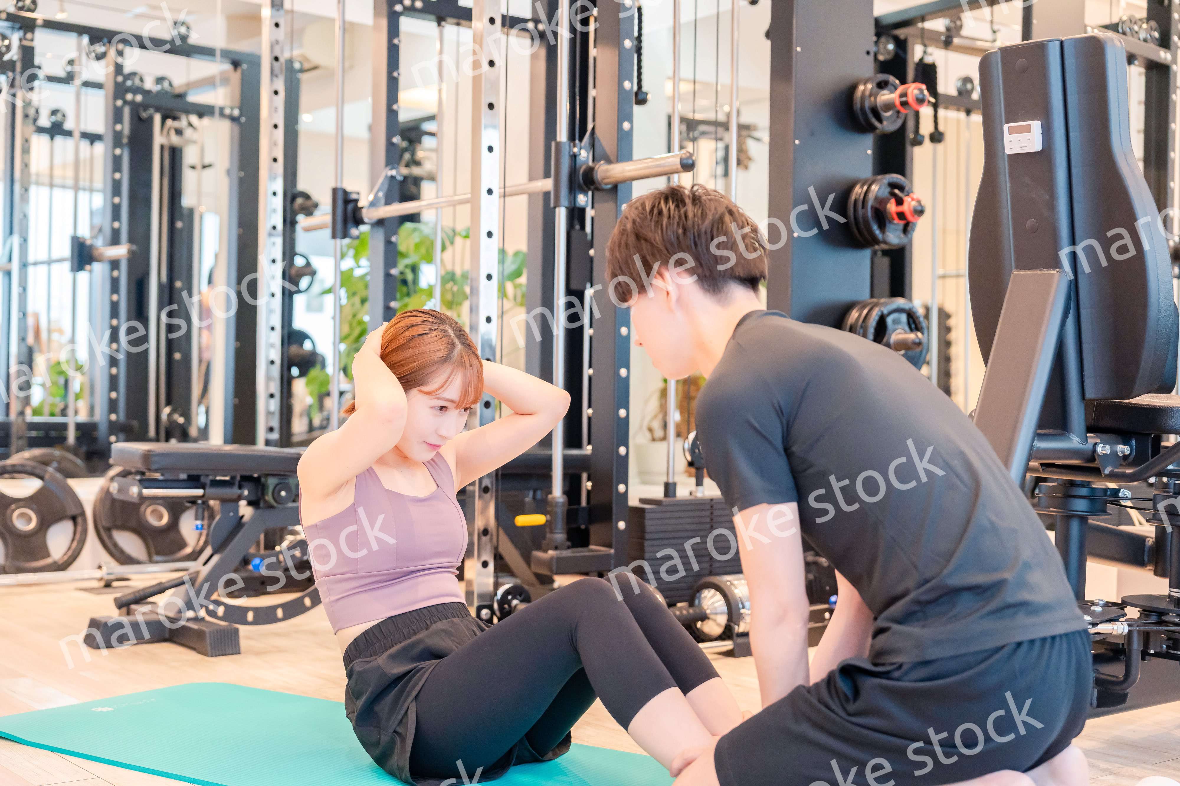 パーソナルジムに通う女性とトレーナー