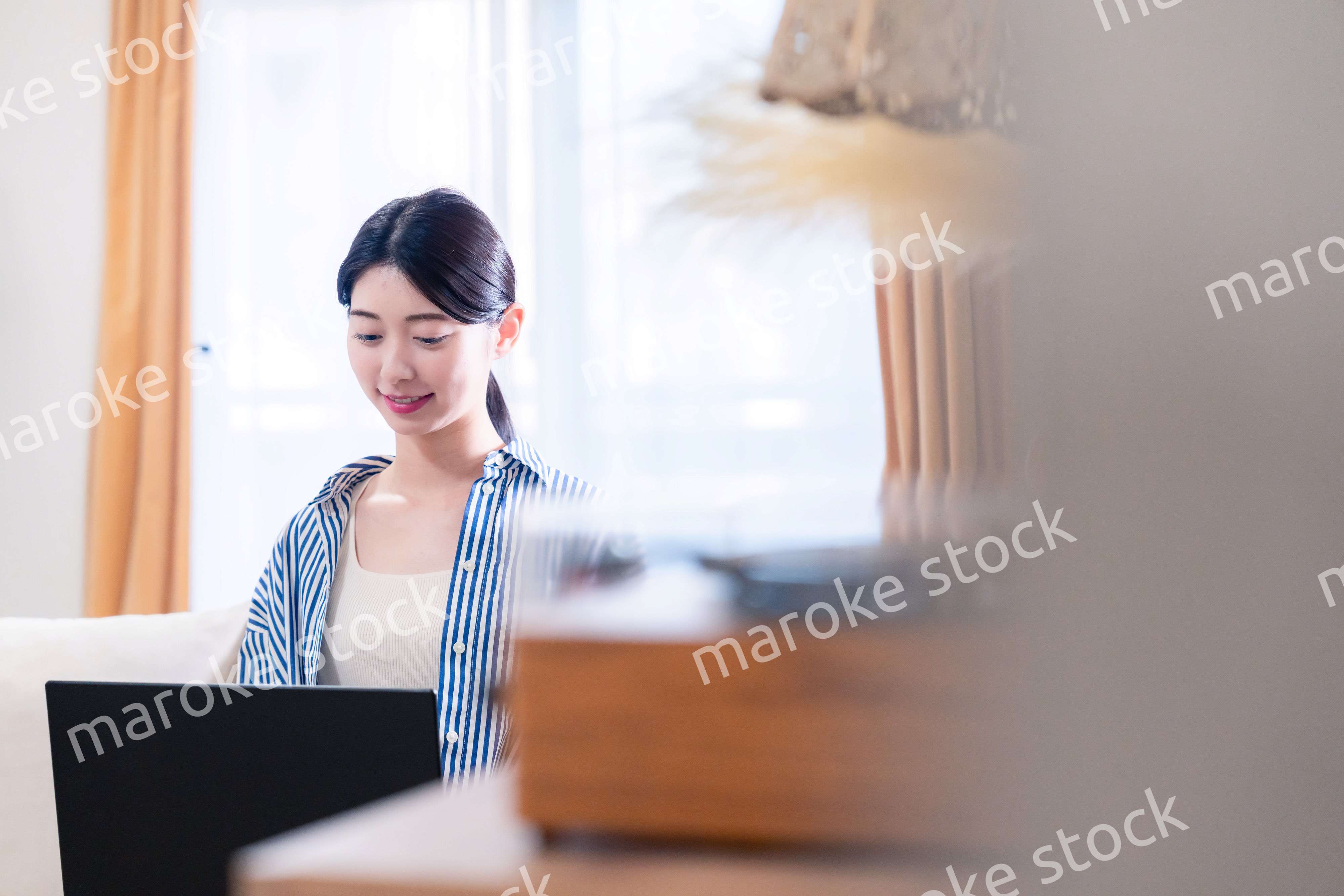 家でリラックスをしてパソコンを使う若い女性