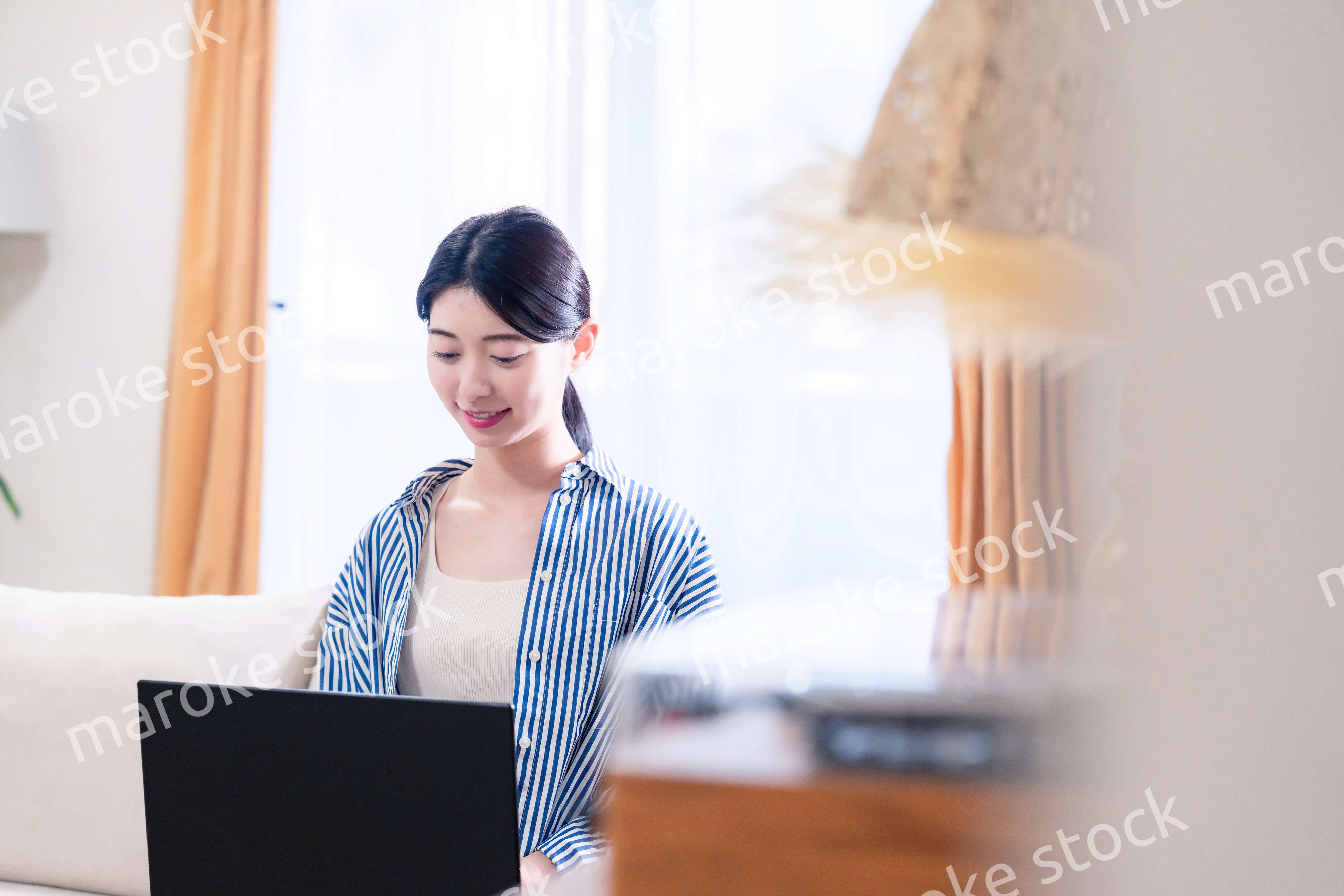 家でリラックスをしてパソコンを使う若い女性