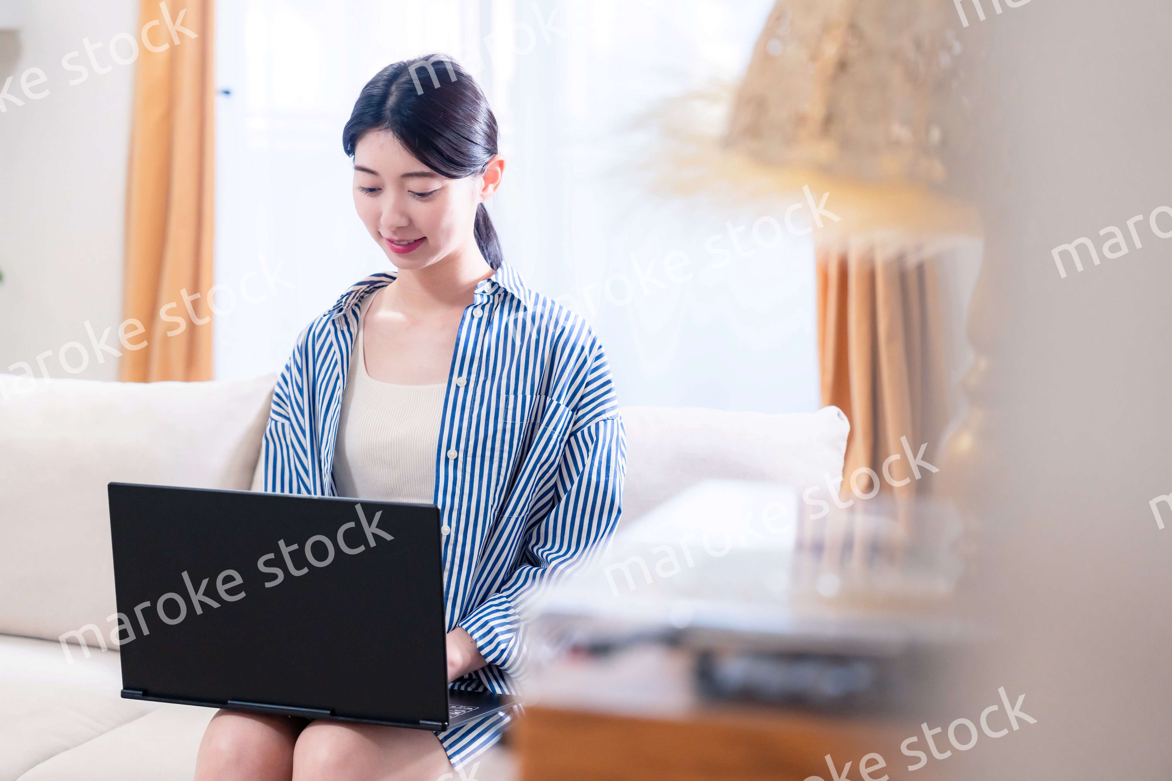 家でリラックスをしてパソコンを使う若い女性