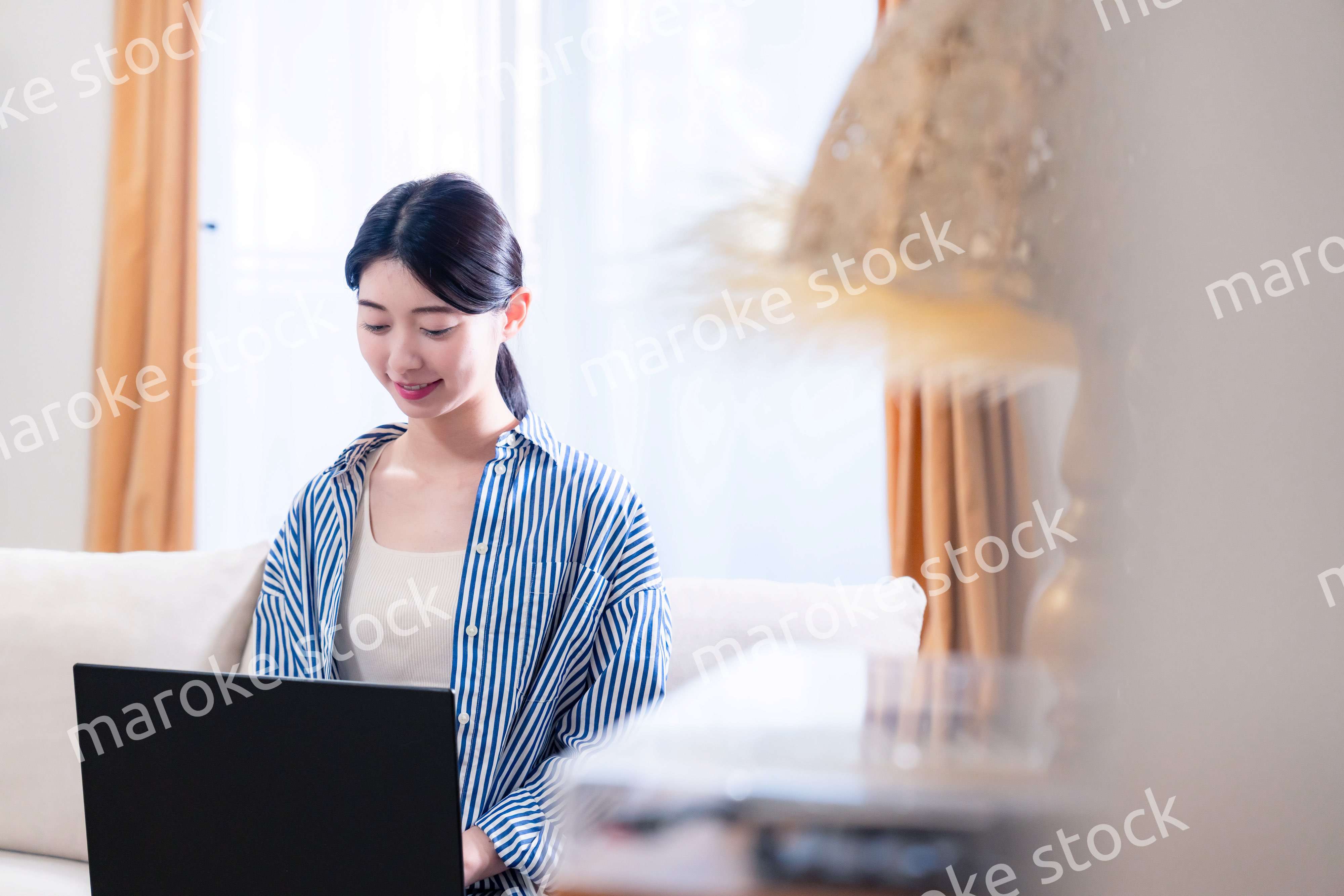 家でリラックスをしてパソコンを使う若い女性