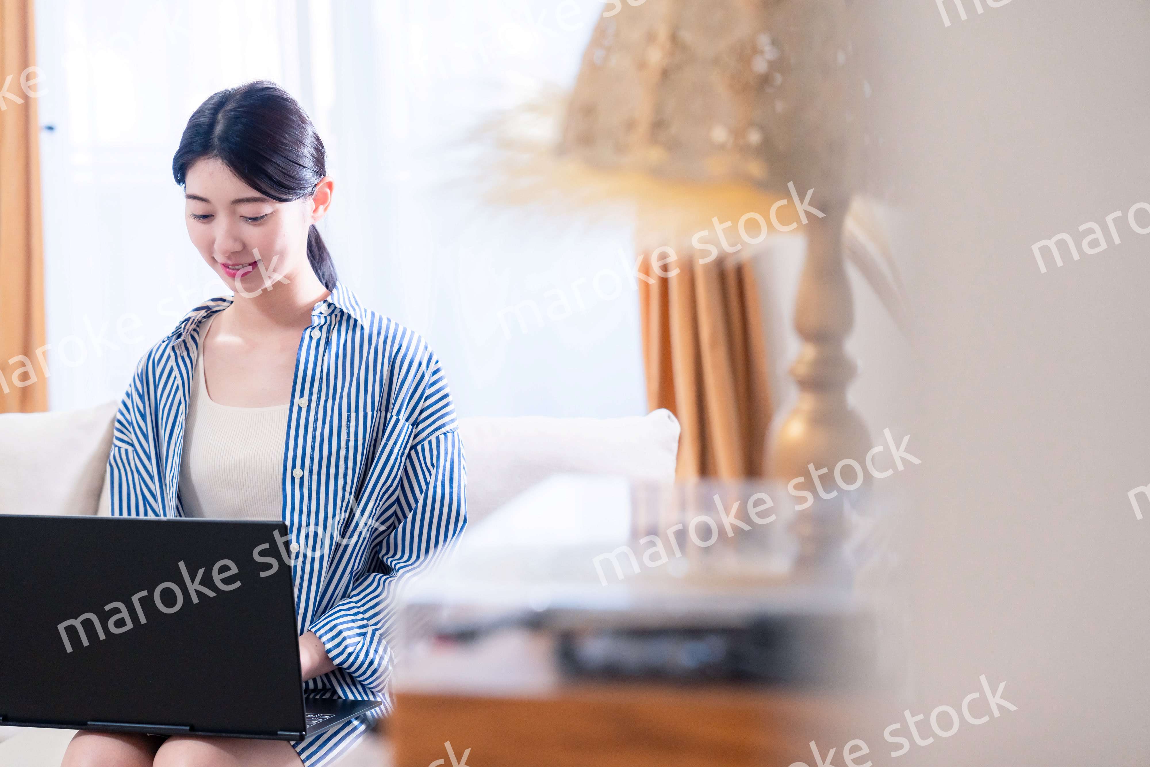 家でリラックスをしてパソコンを使う若い女性