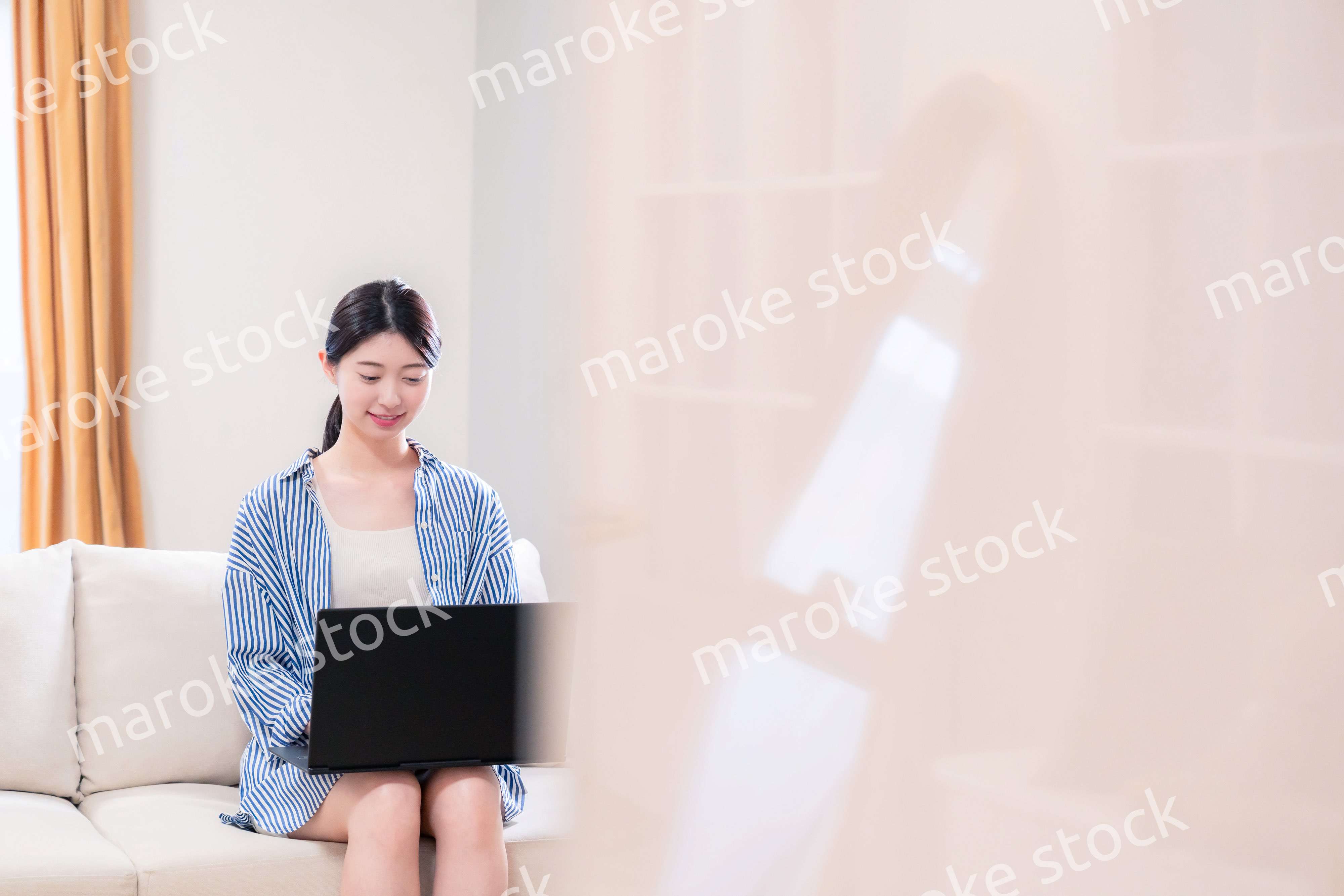 家でリラックスをしてパソコンを使う若い女性