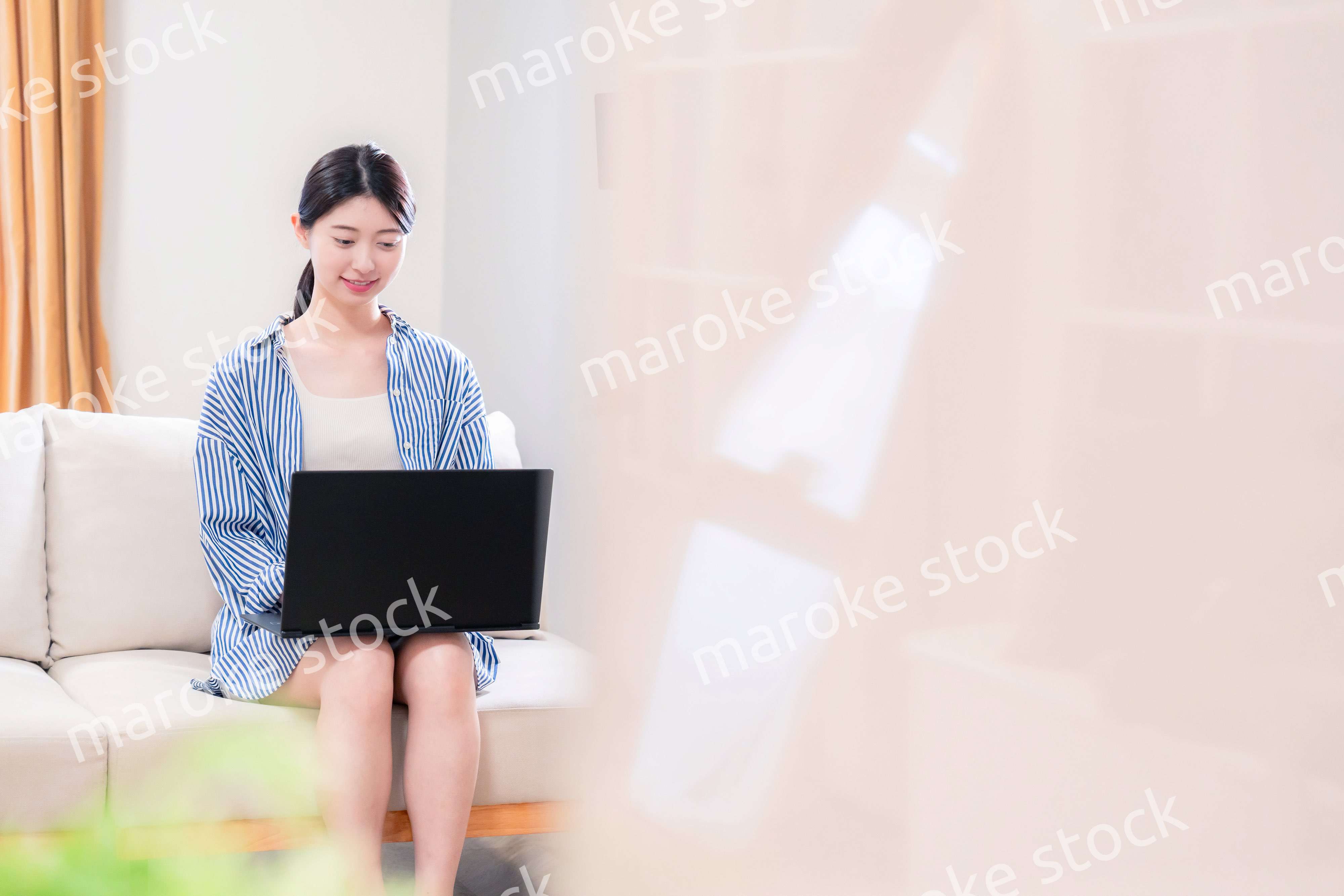 家でリラックスをしてパソコンを使う若い女性