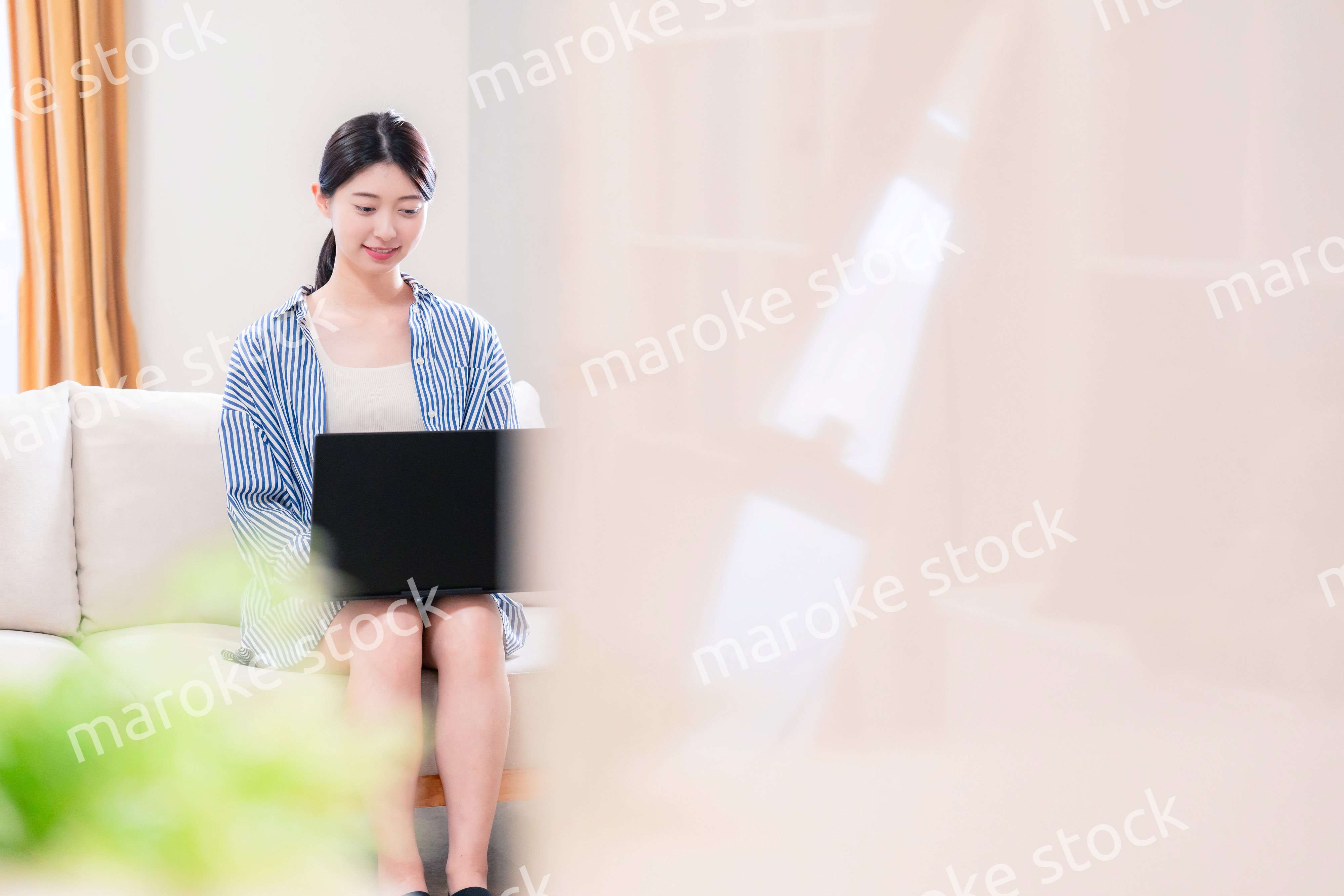 家でリラックスをしてパソコンを使う若い女性