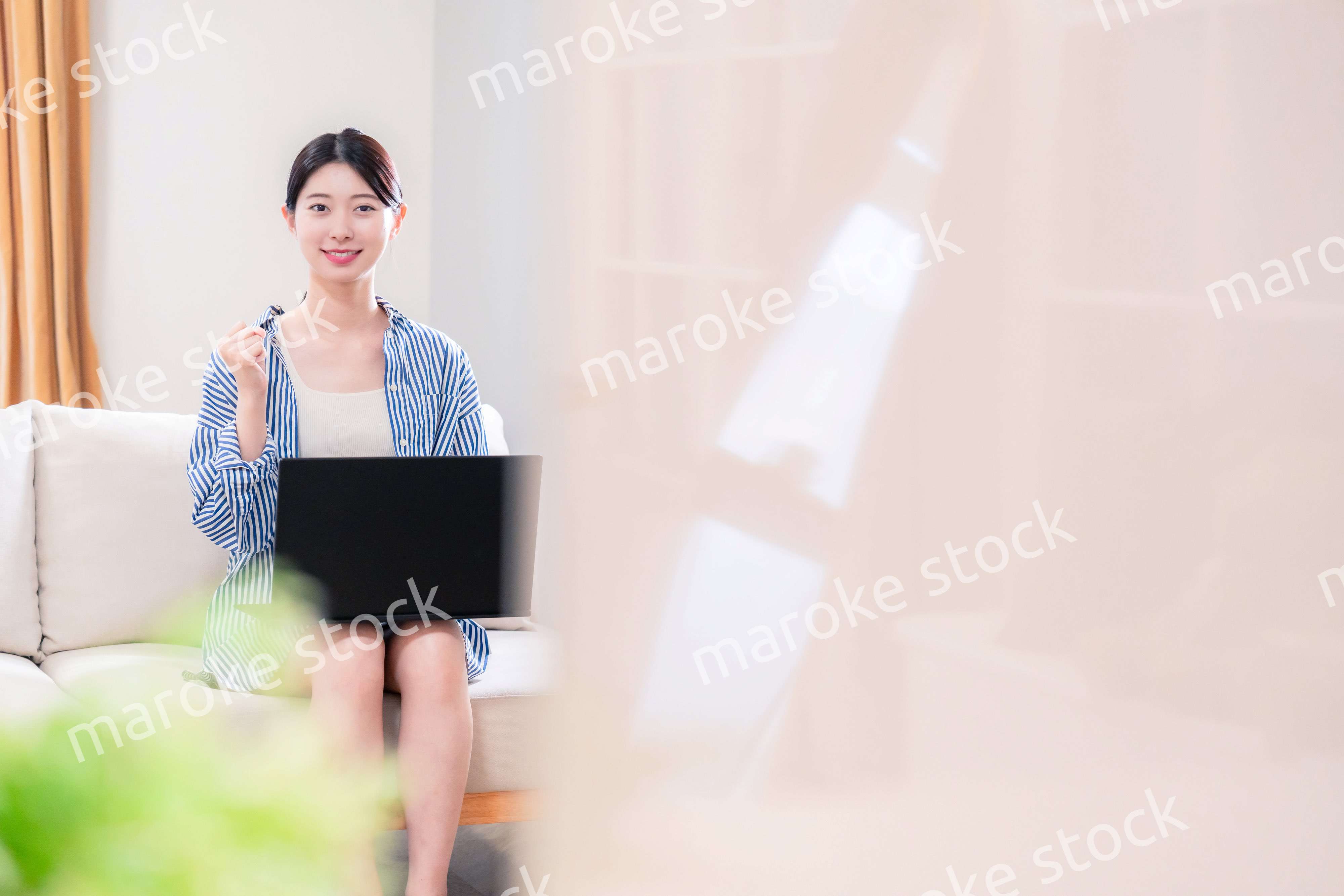 家でリラックスをしてパソコンを使う若い女性