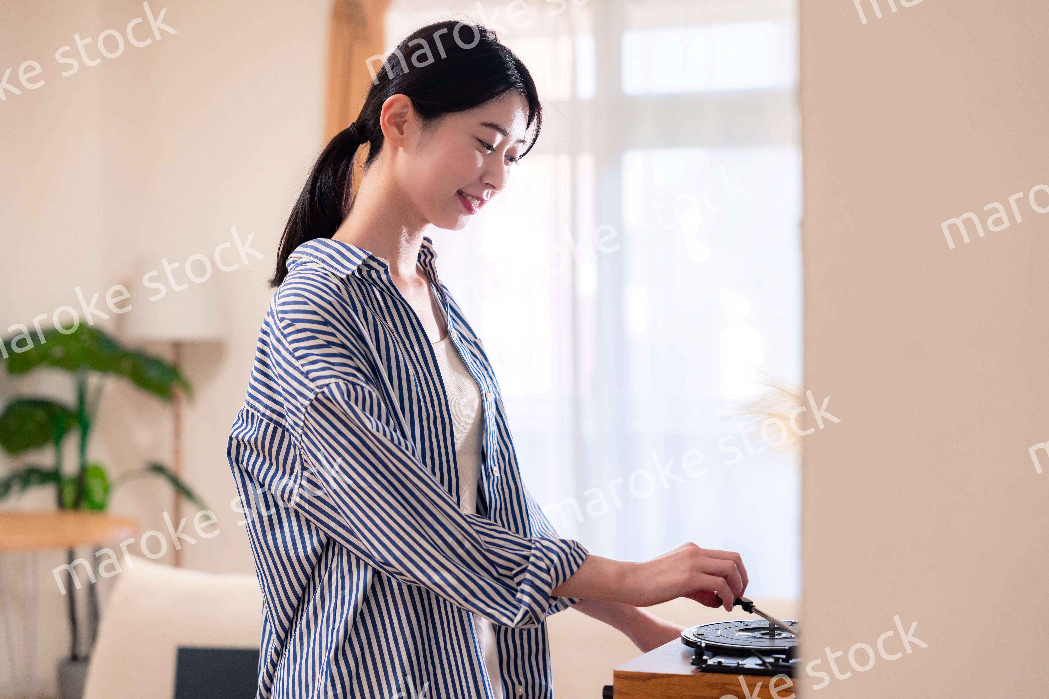 家でレコードを聴く若い女性