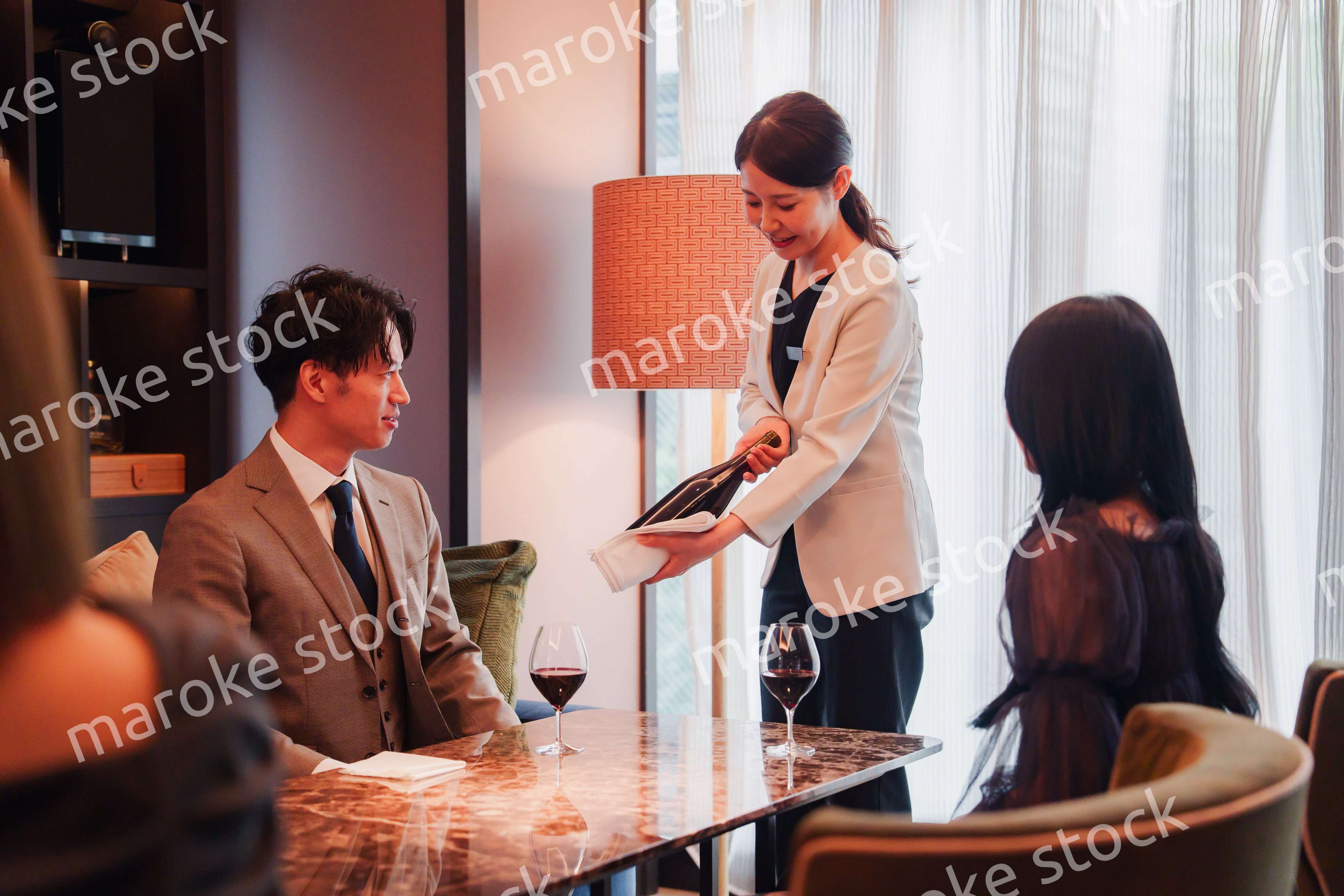 ワインをお客様におすすめをする女性のスタッフ