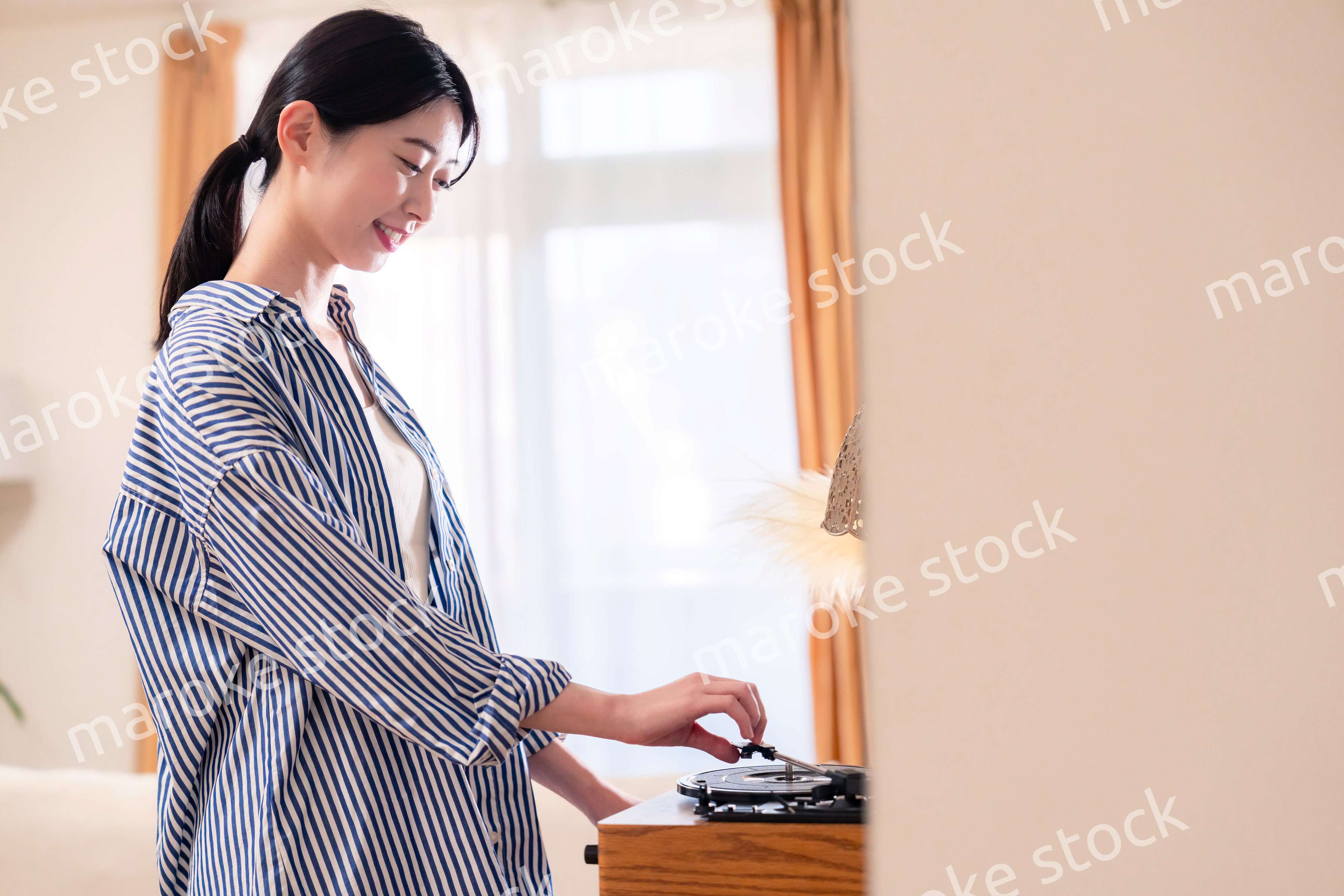 家でレコードを聴く若い女性