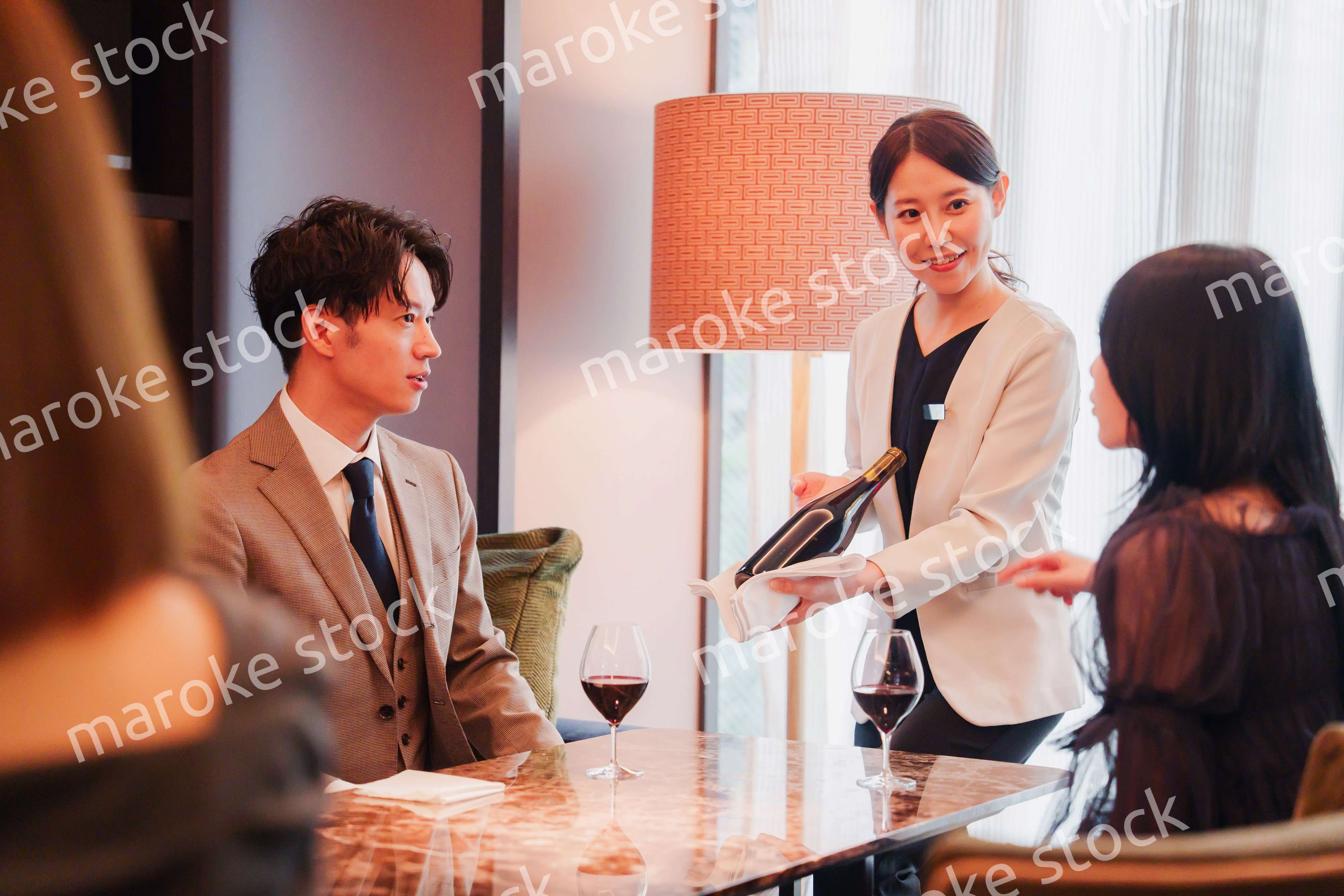 ワインをお客様におすすめをする女性のスタッフ