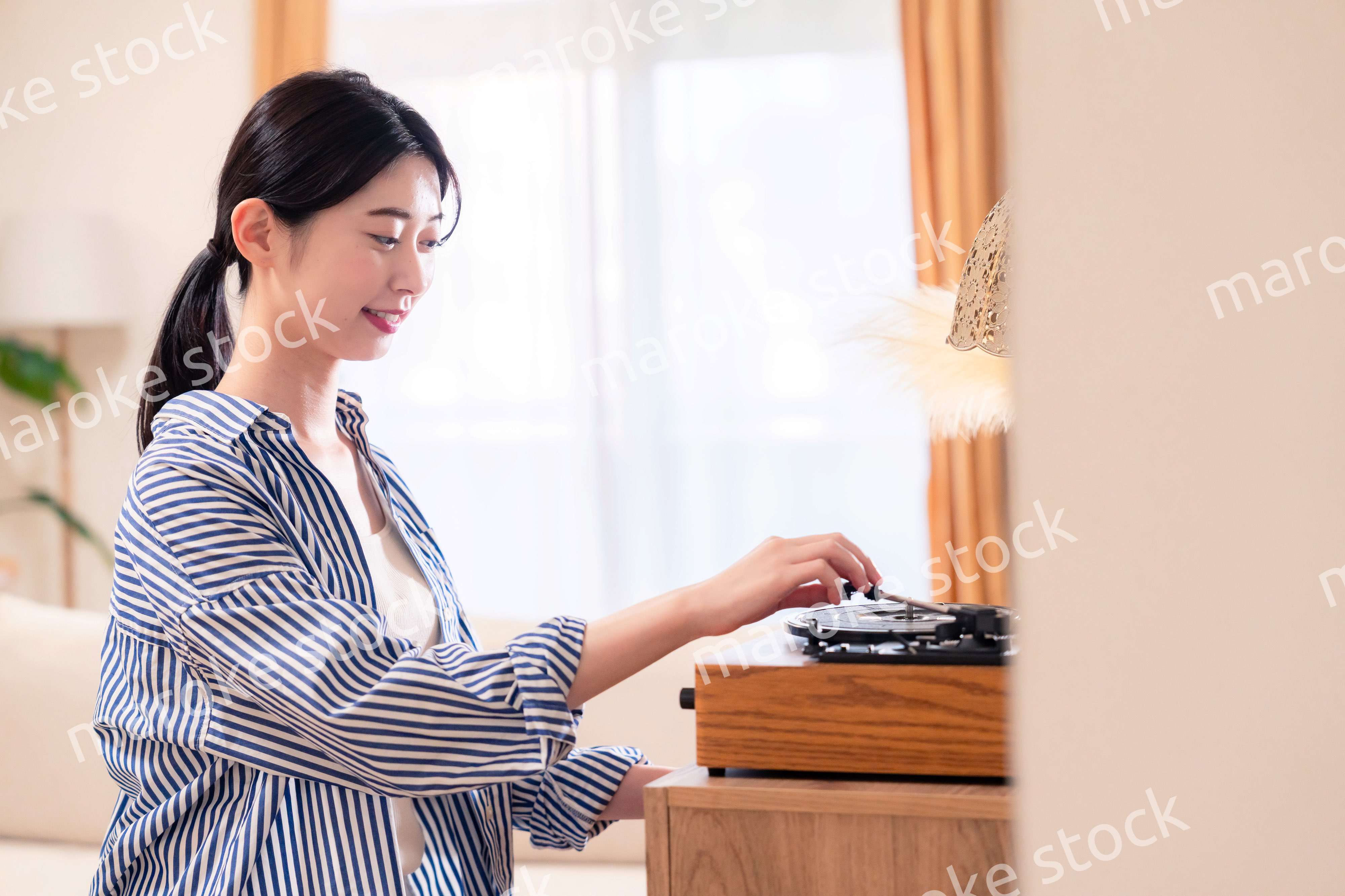 家でレコードを聴く若い女性