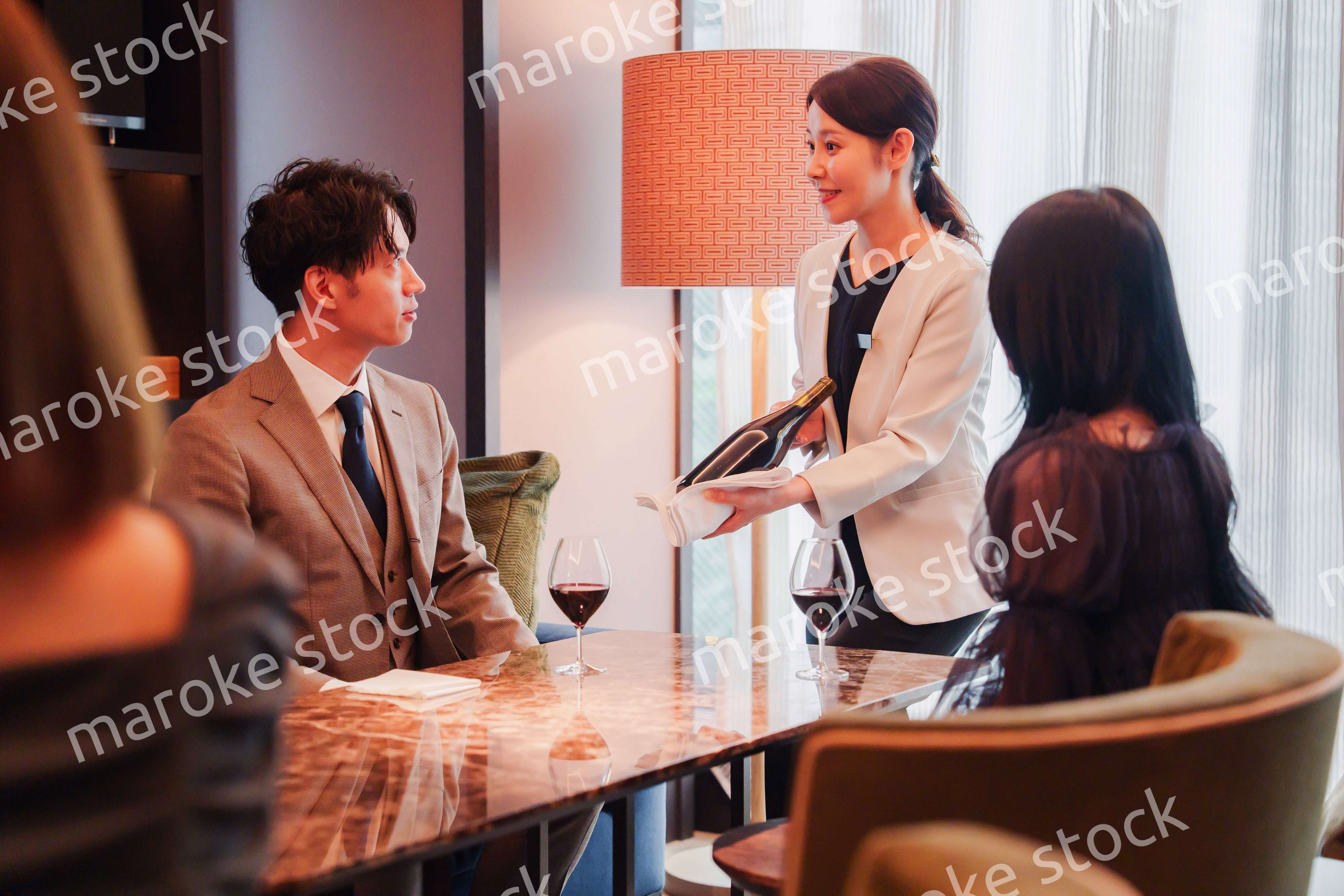 ワインをお客様におすすめをする女性のスタッフ