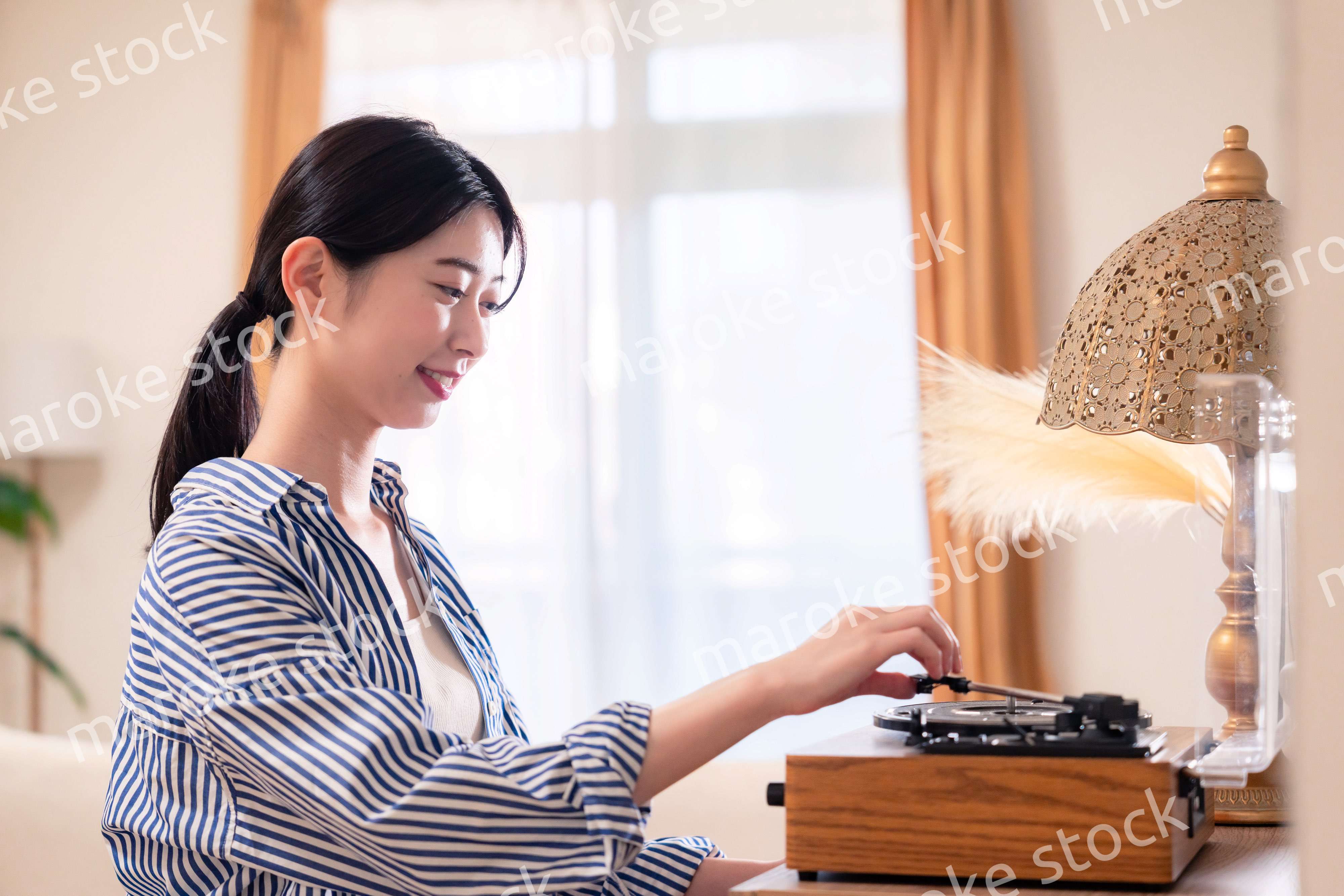 家でレコードを聴く若い女性