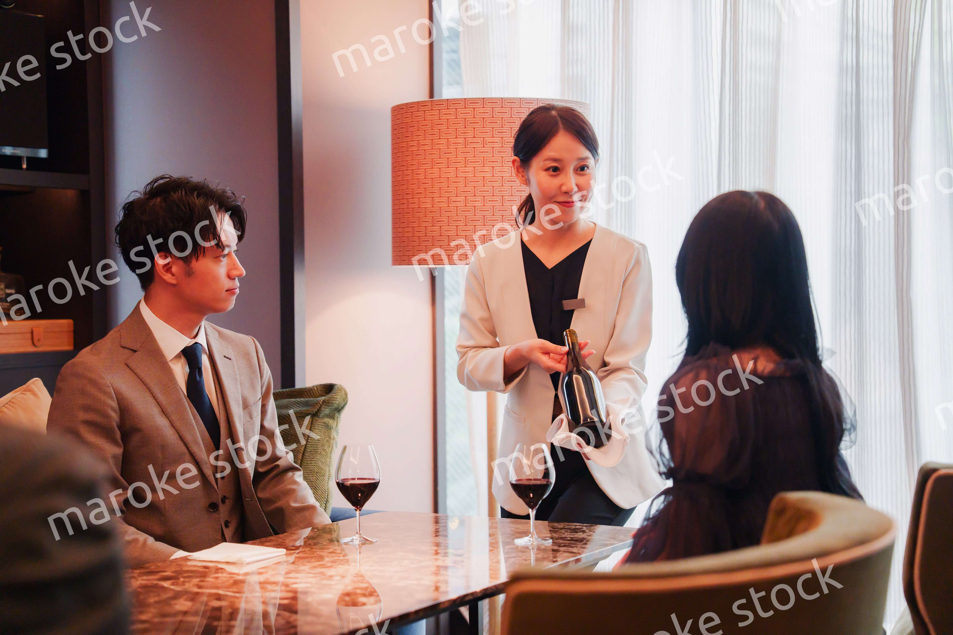 ワインをお客様におすすめをする女性のスタッフ