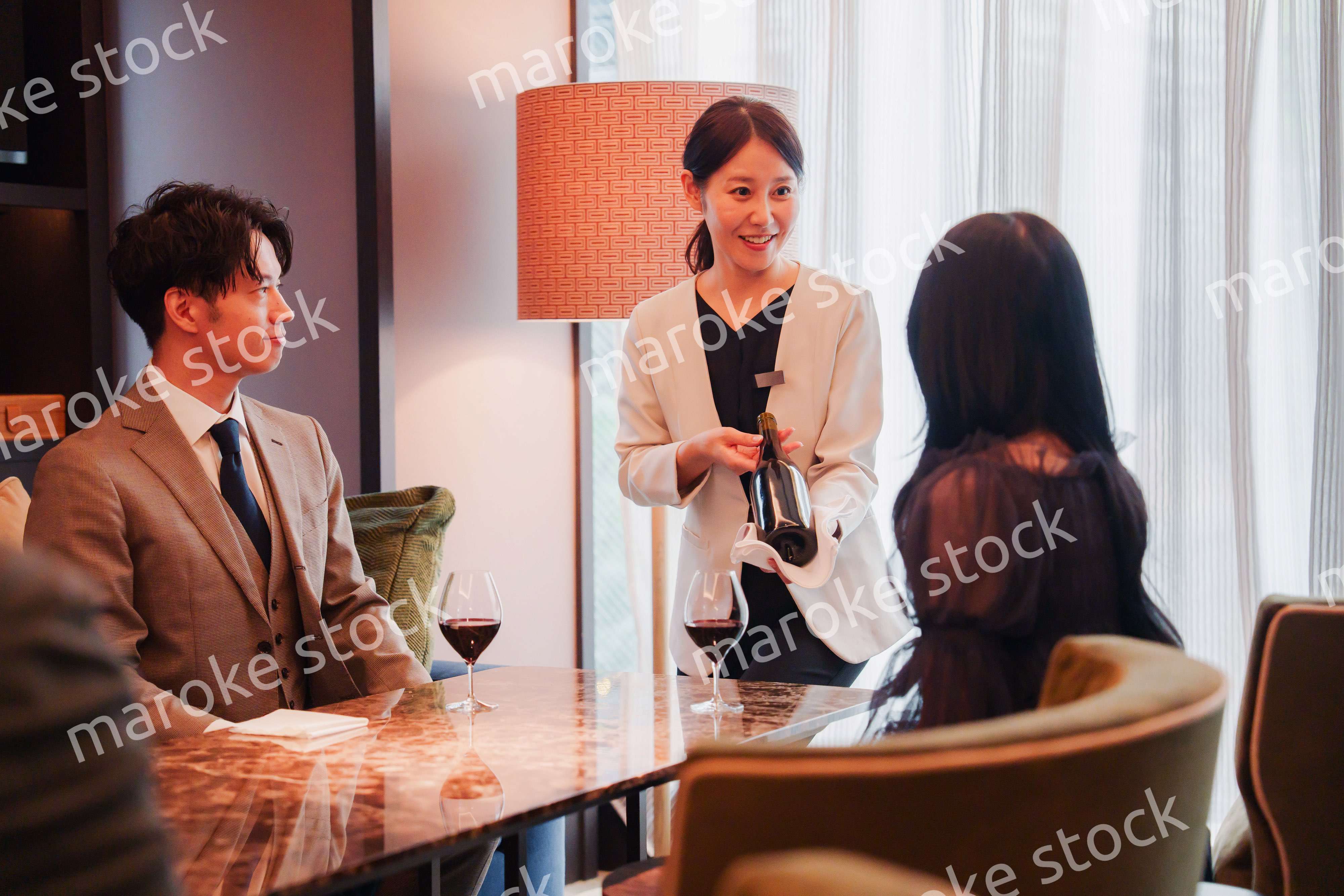 ワインをお客様におすすめをする女性のスタッフ