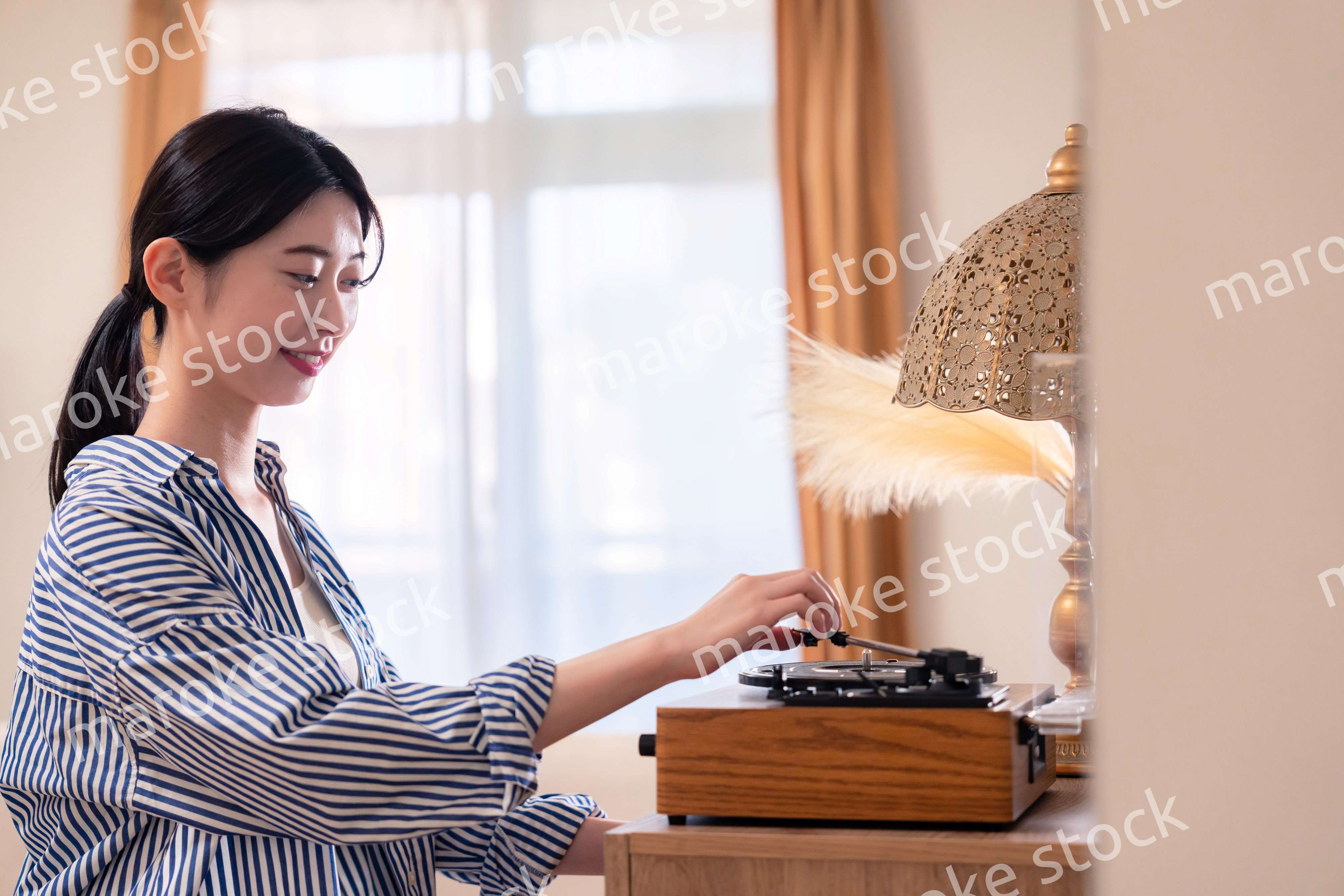 家でレコードを聴く若い女性