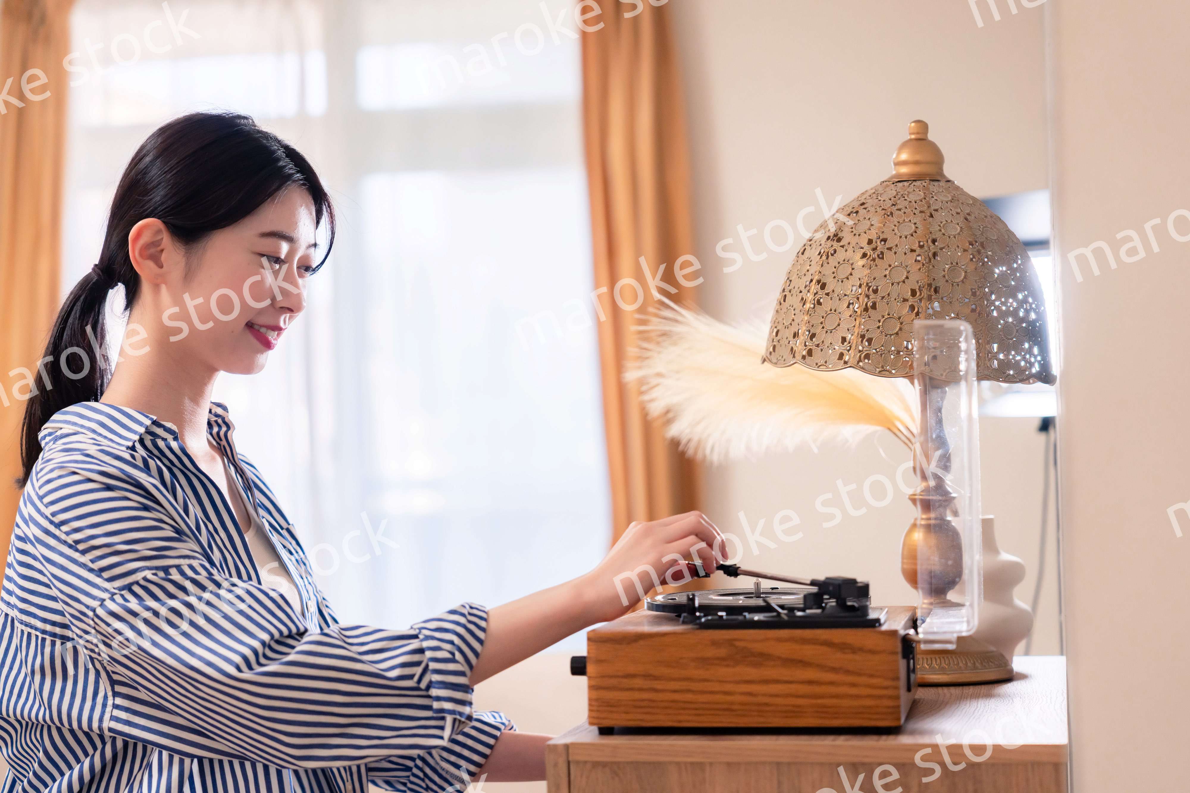 家でレコードを聴く若い女性