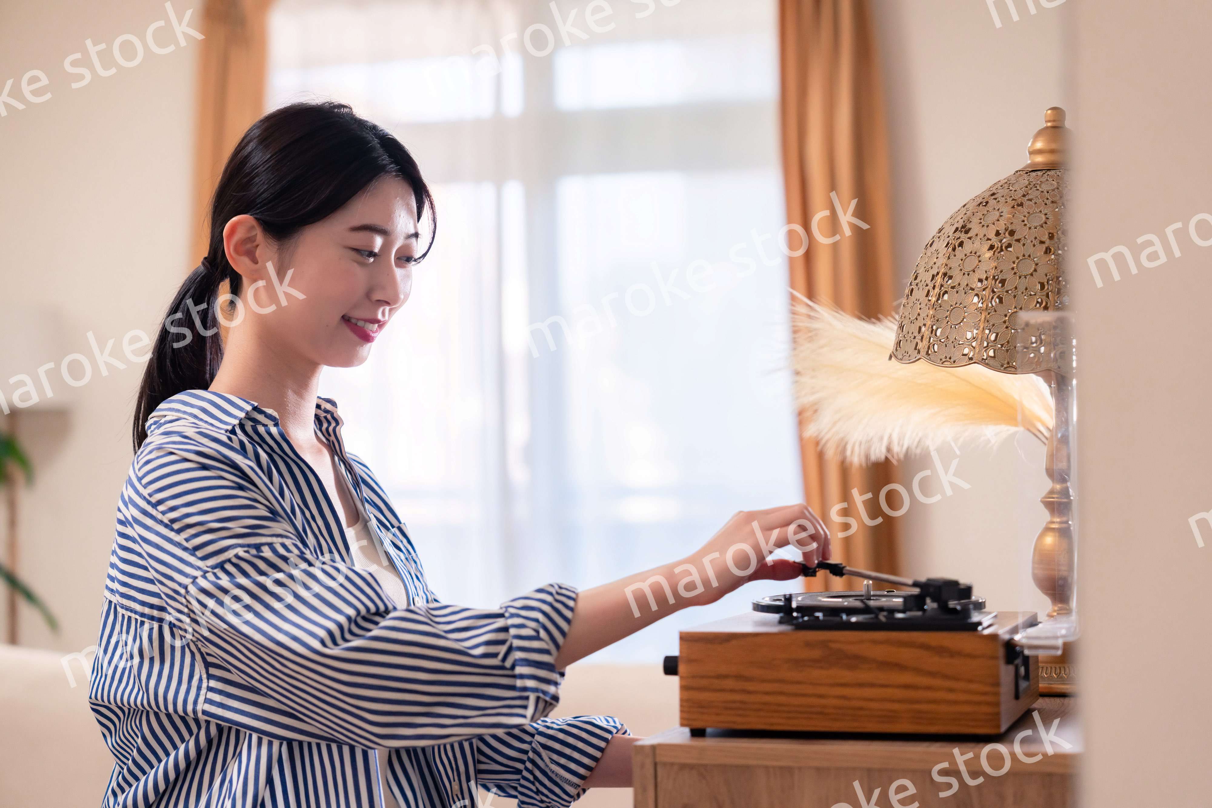 家でレコードを聴く若い女性