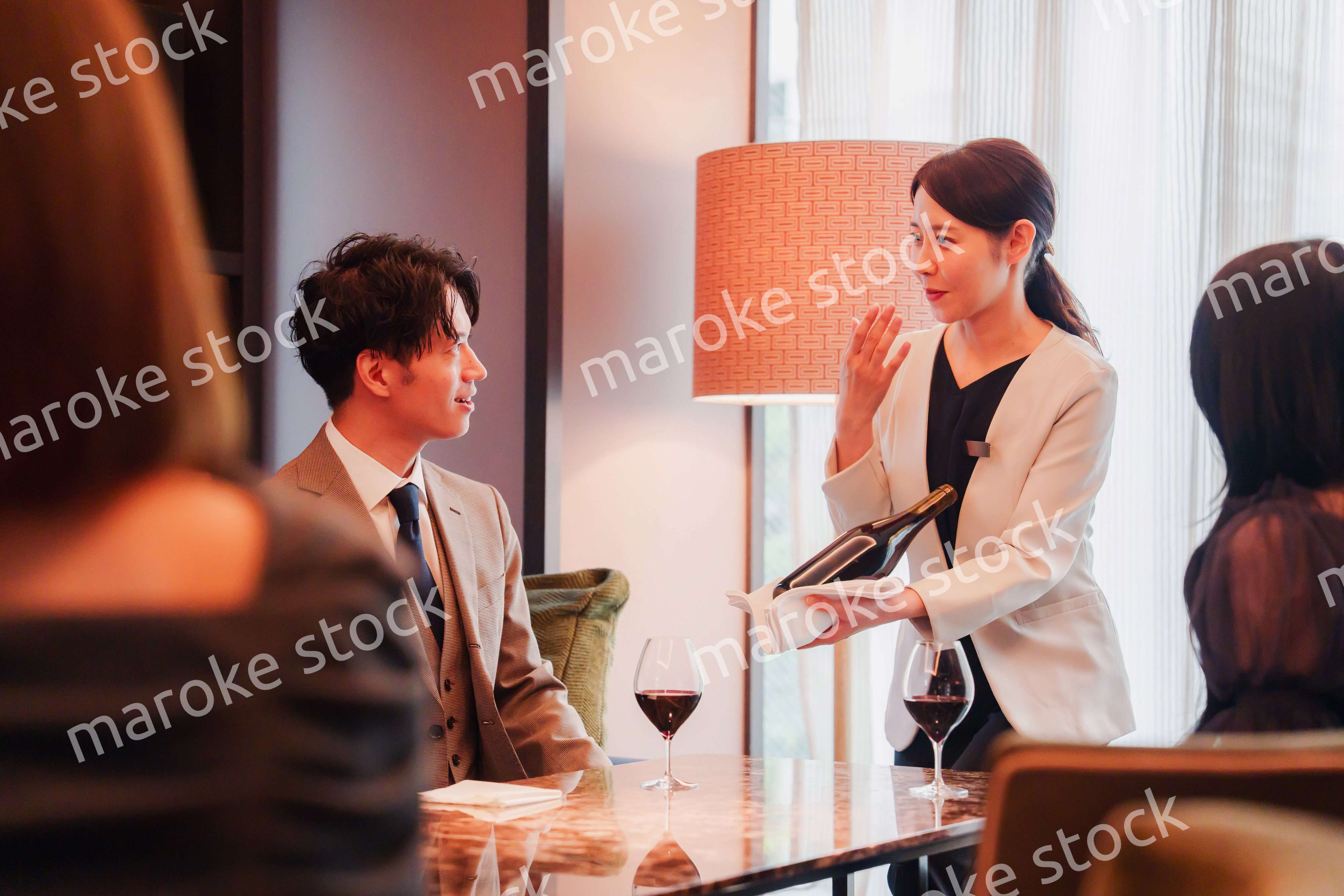 ワインをお客様におすすめをする女性のスタッフ