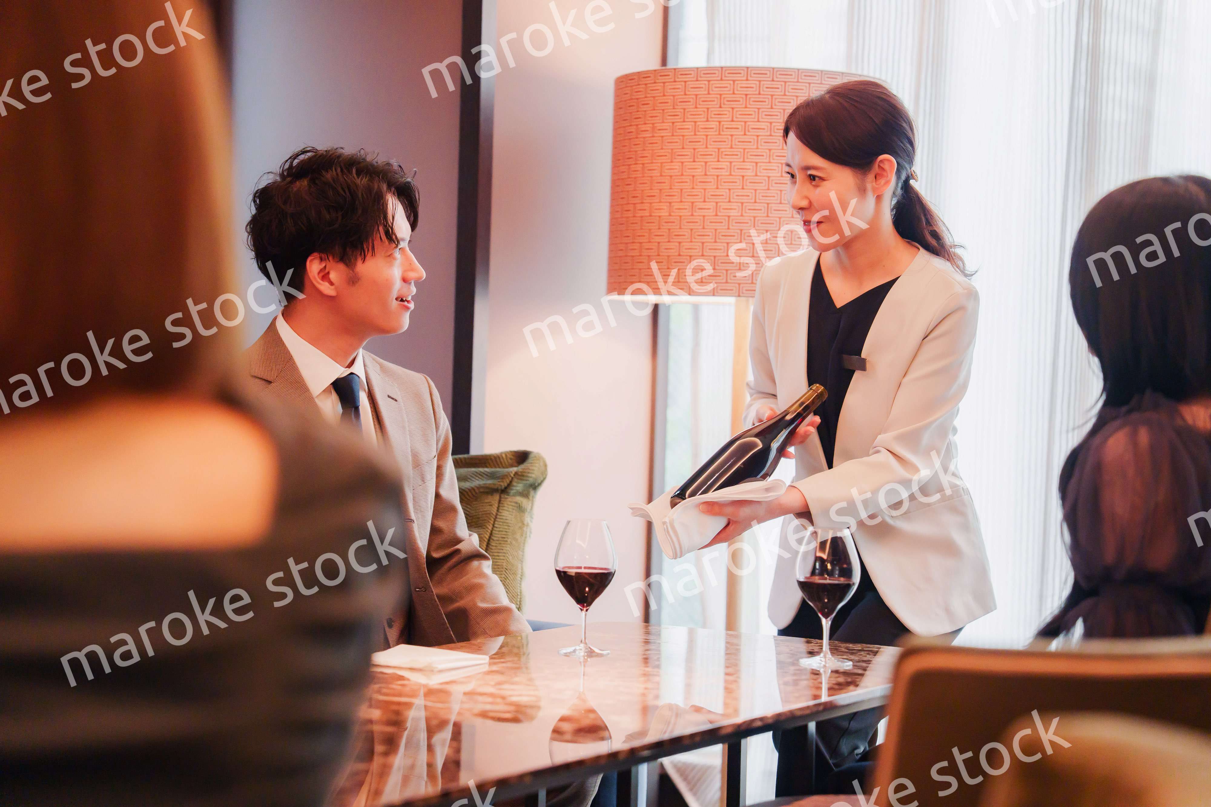 ワインをお客様におすすめをする女性のスタッフ