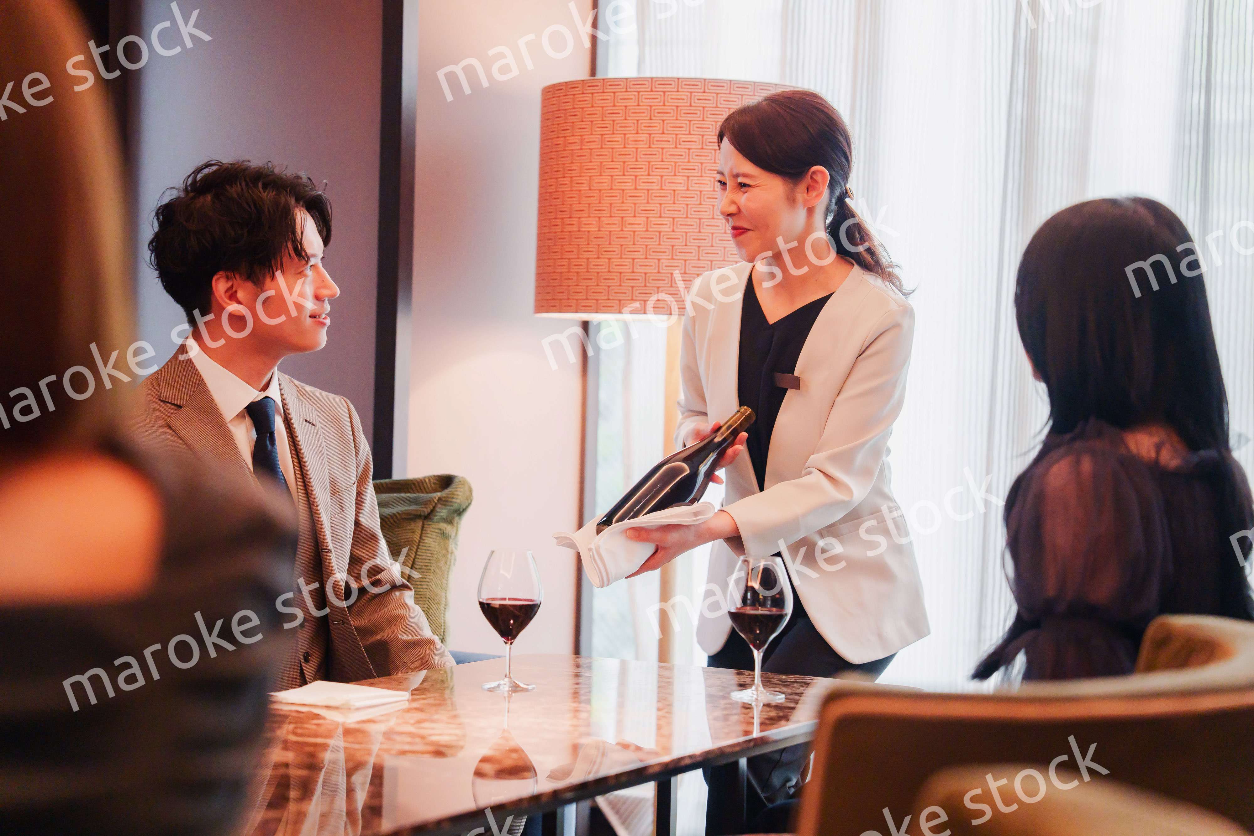 ワインをお客様におすすめをする女性のスタッフ