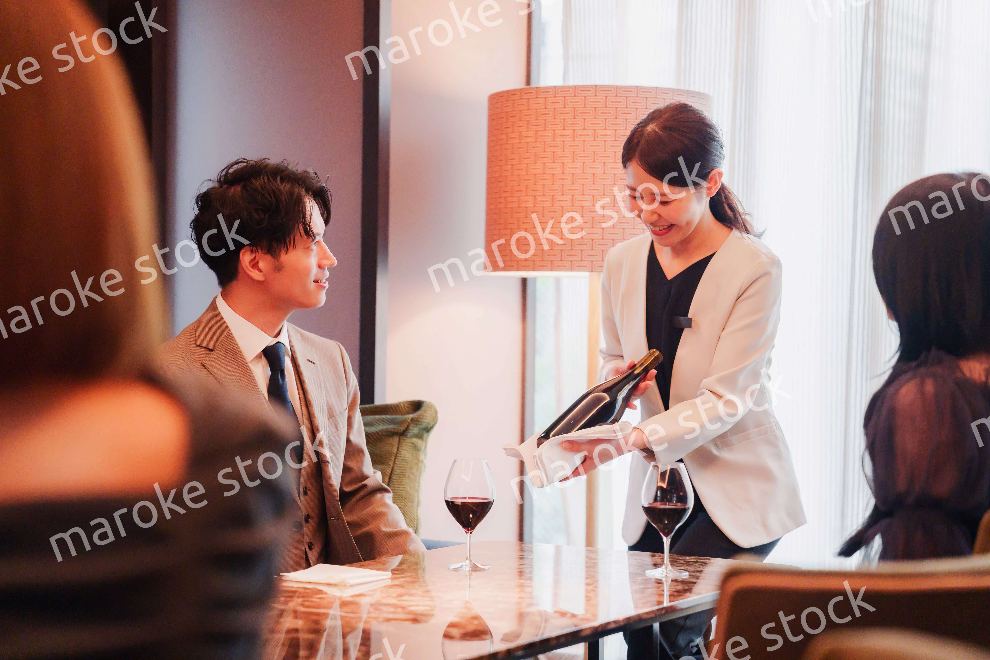 ワインをお客様におすすめをする女性のスタッフ