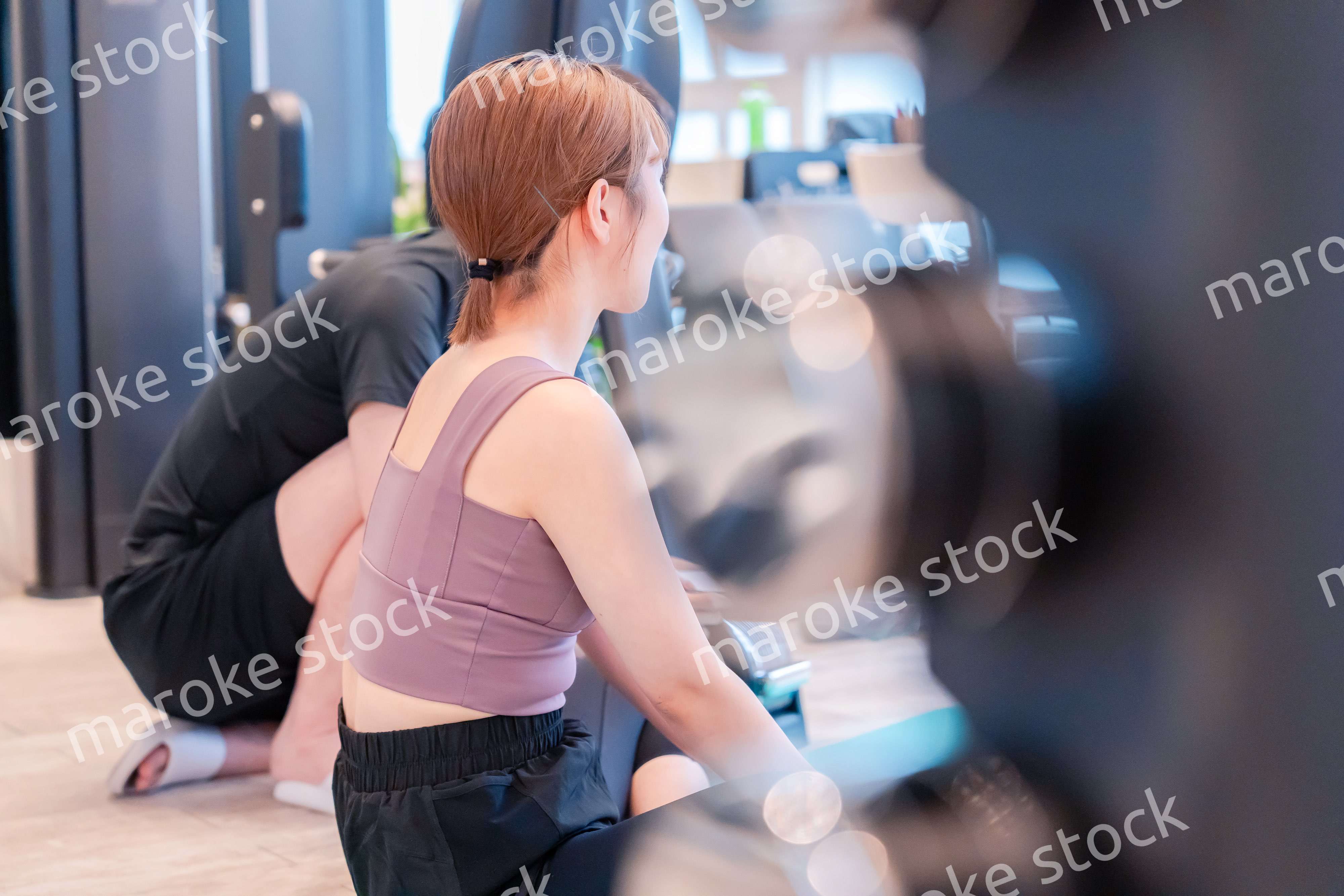 パーソナルジムに通う女性とトレーナー