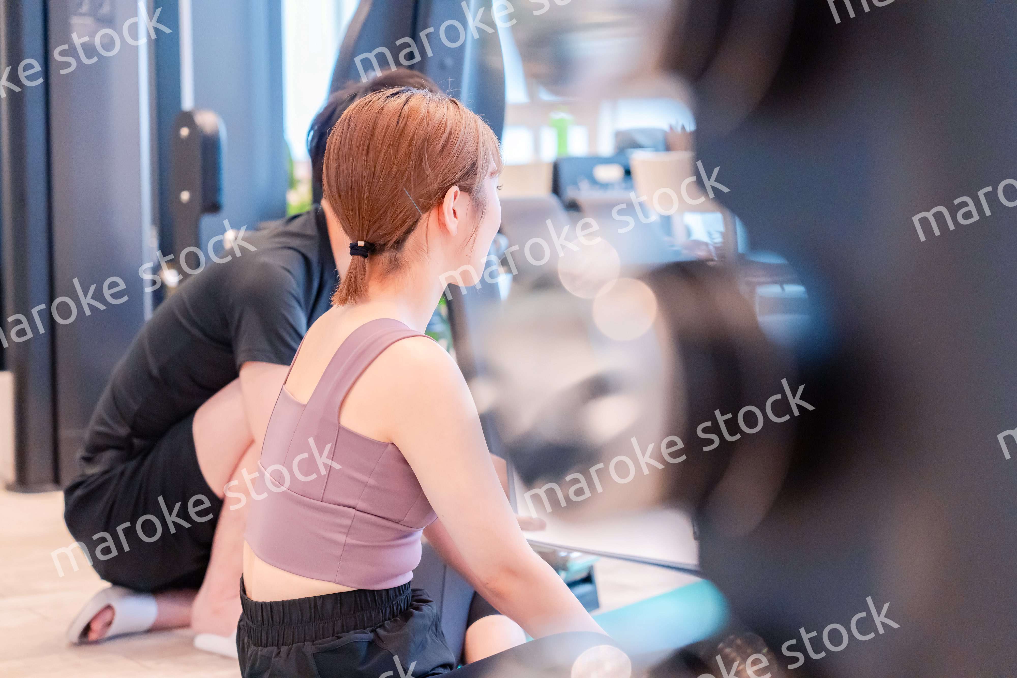 パーソナルジムに通う女性とトレーナー