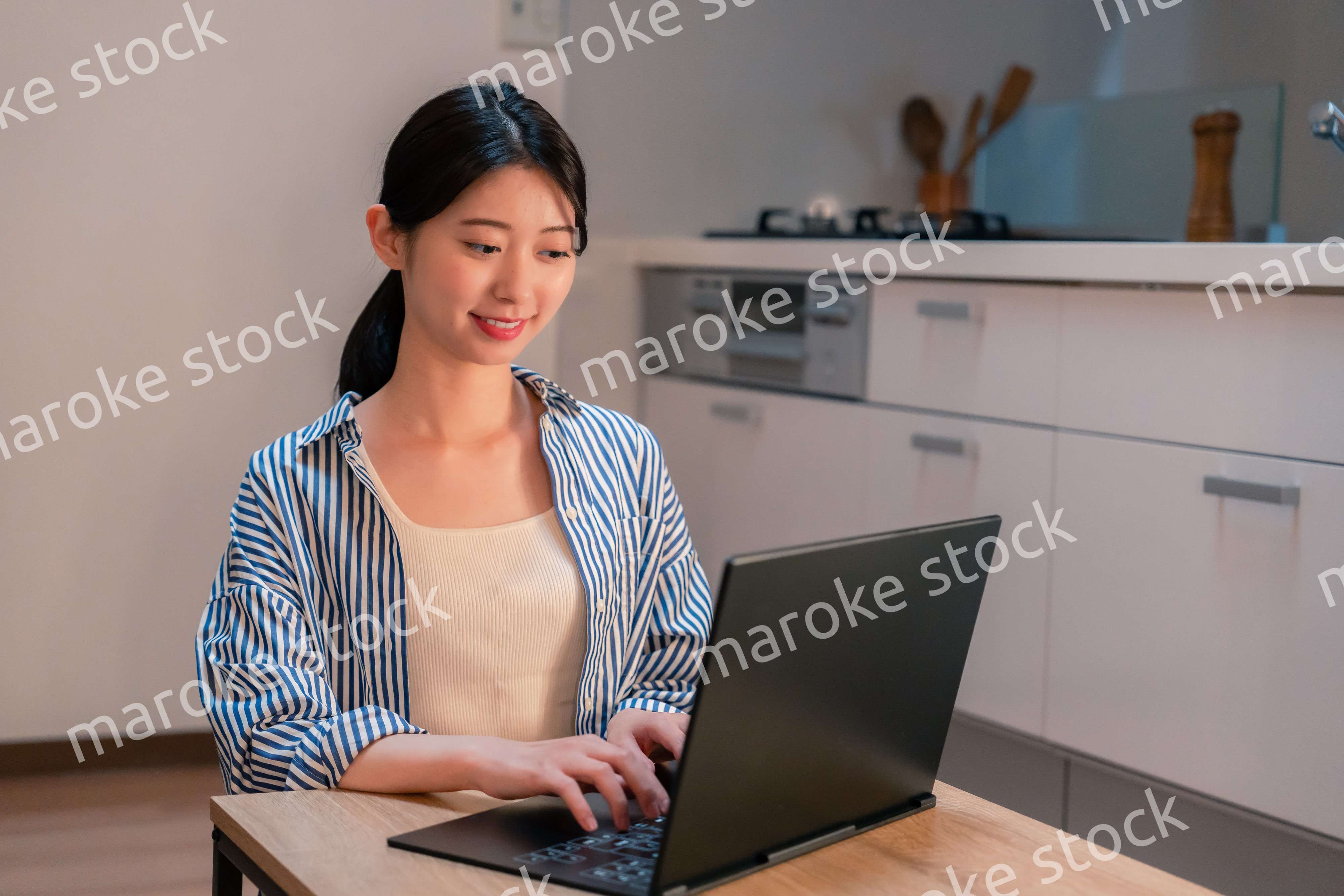 夜遅くまで在宅勤務をする若い女性