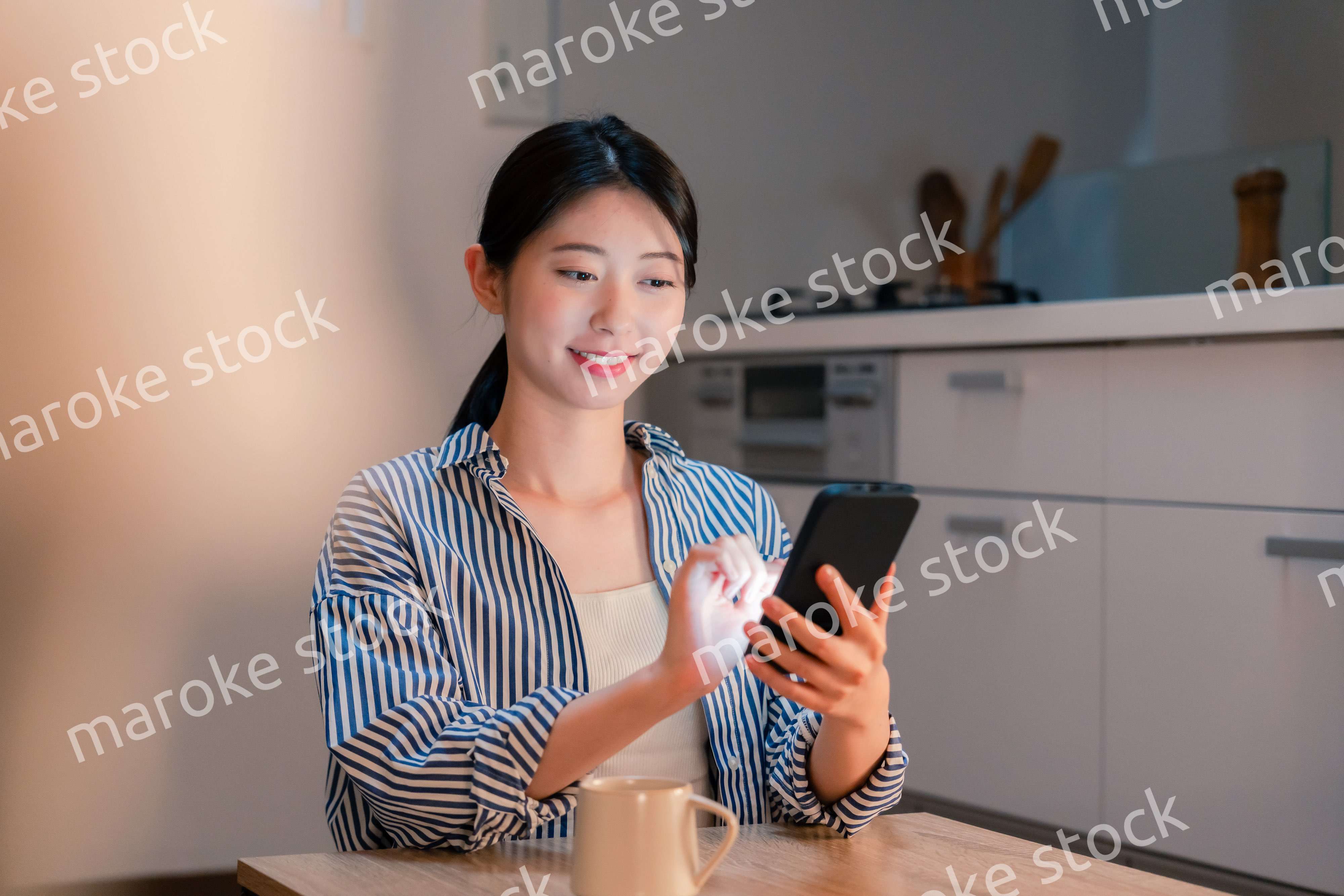 夜遅くに笑顔でスマホを使う若い女性