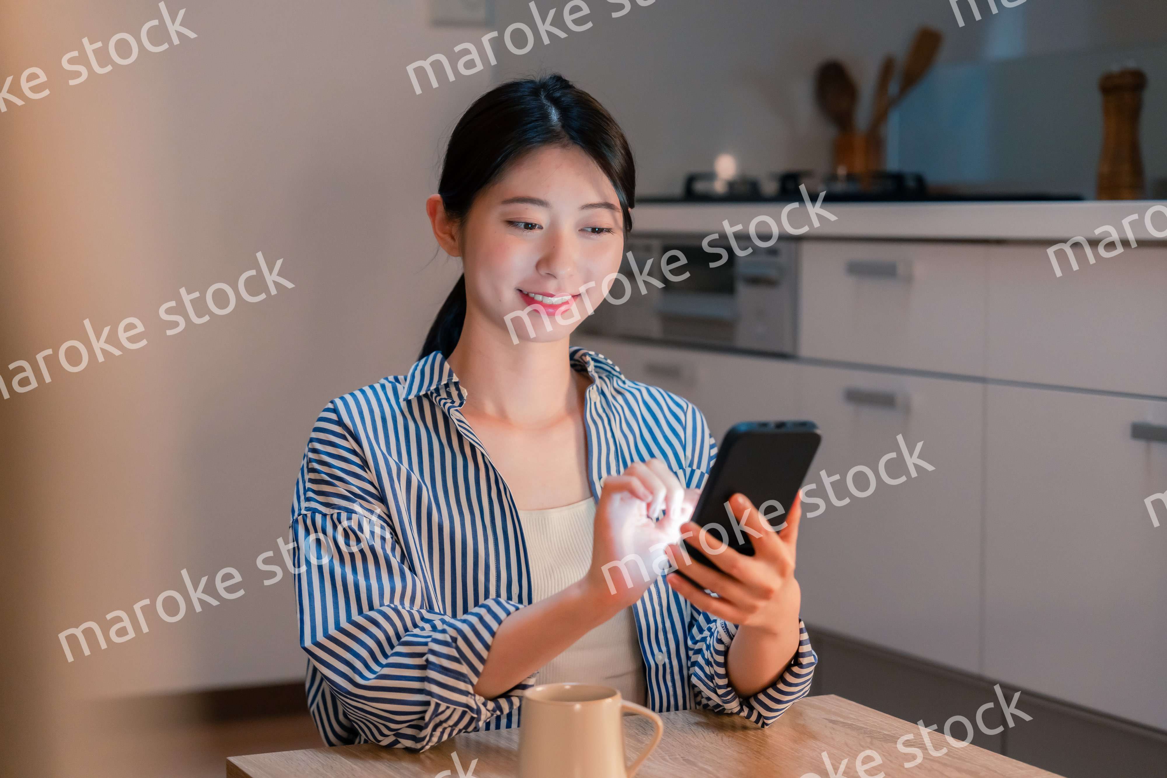 夜遅くに笑顔でスマホを使う若い女性