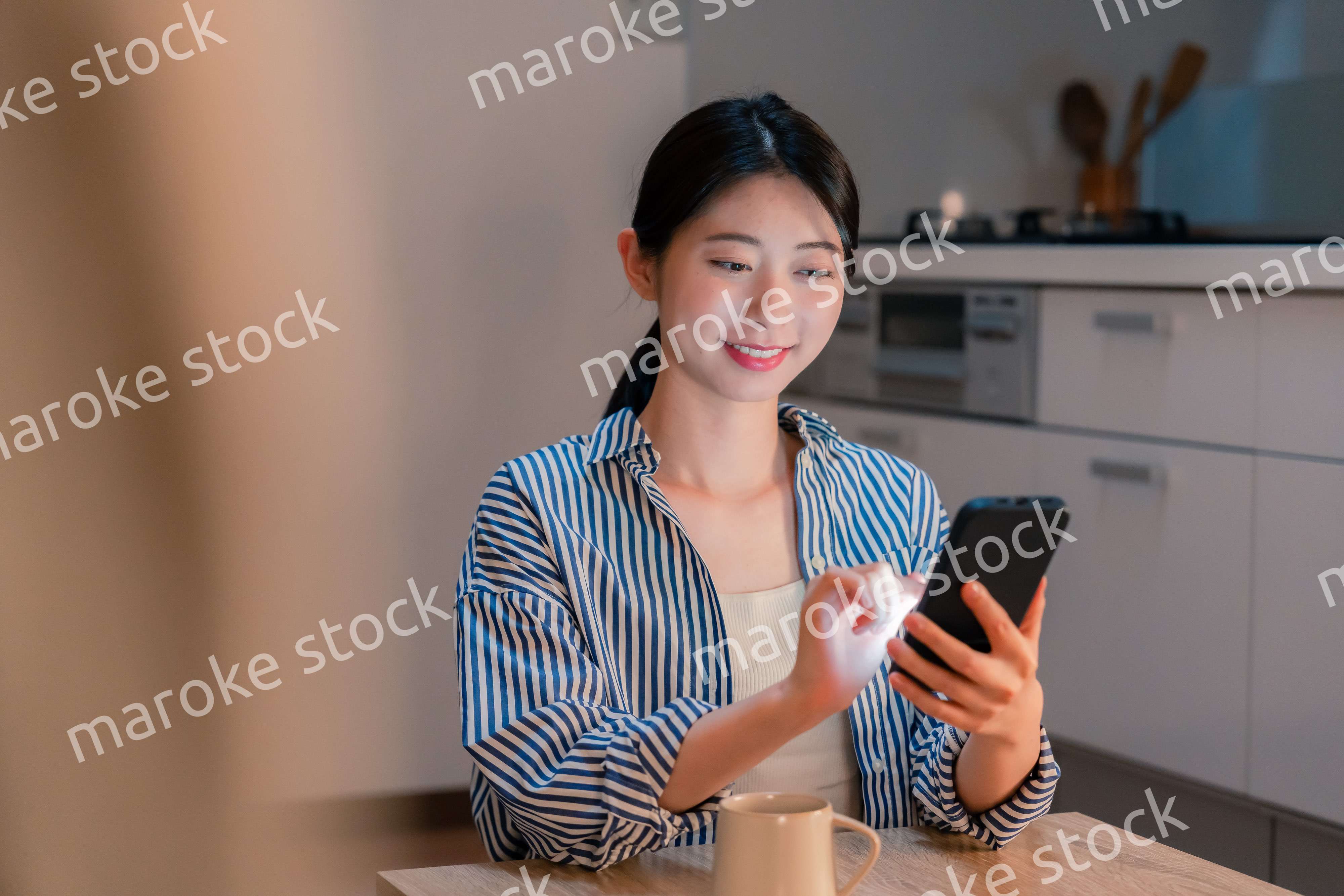 夜遅くに笑顔でスマホを使う若い女性