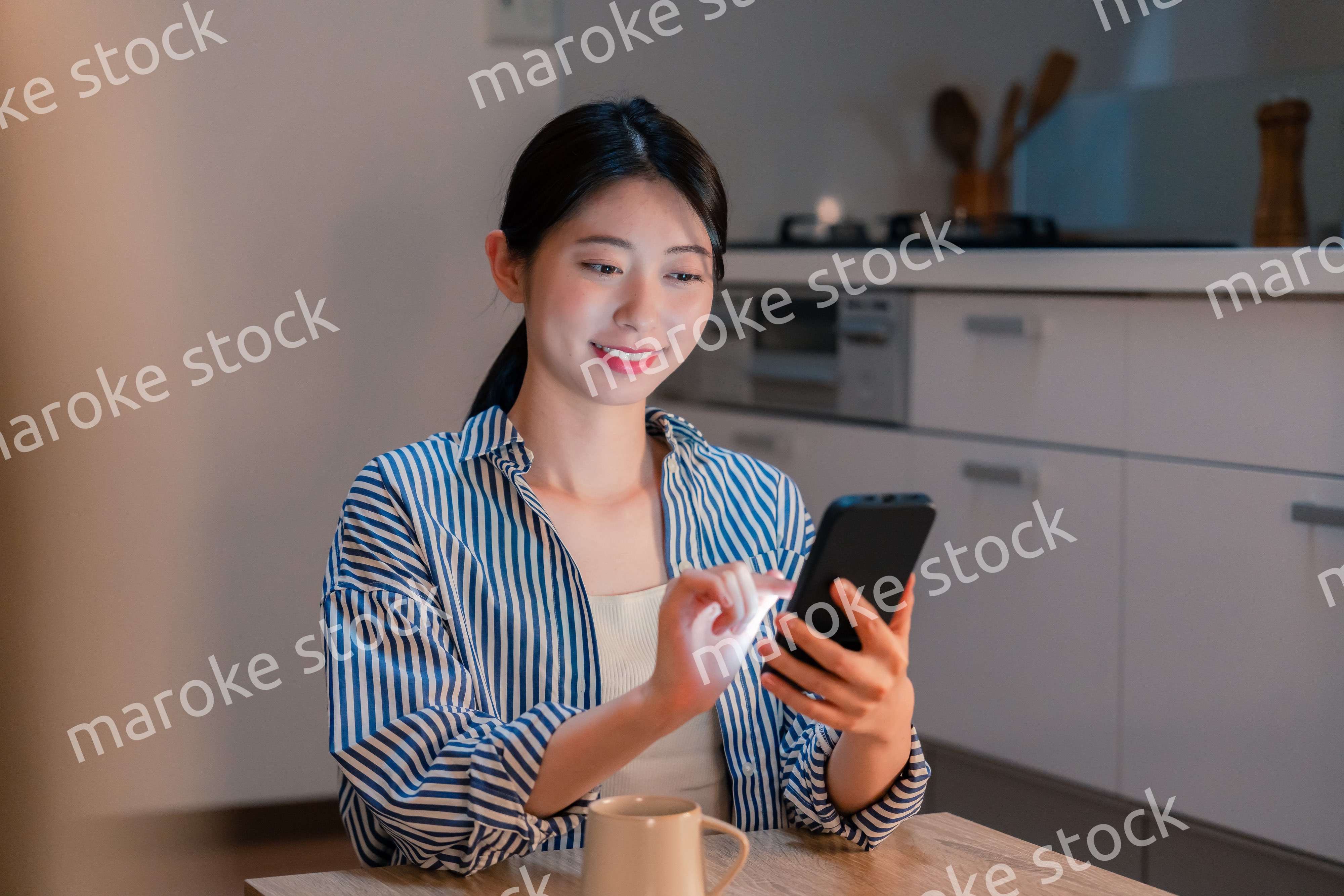 夜遅くに笑顔でスマホを使う若い女性