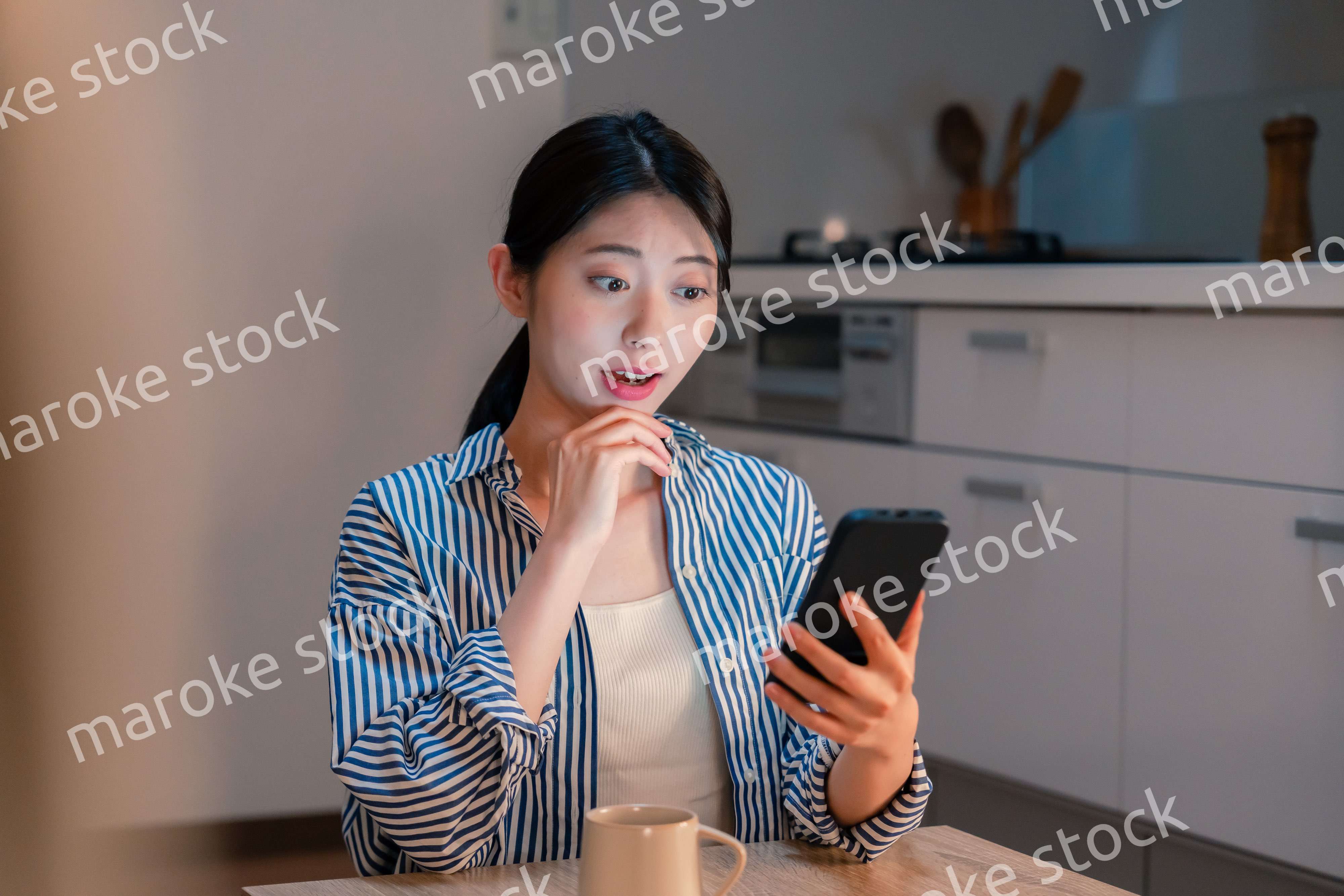 夜遅くに笑顔でスマホを使う若い女性