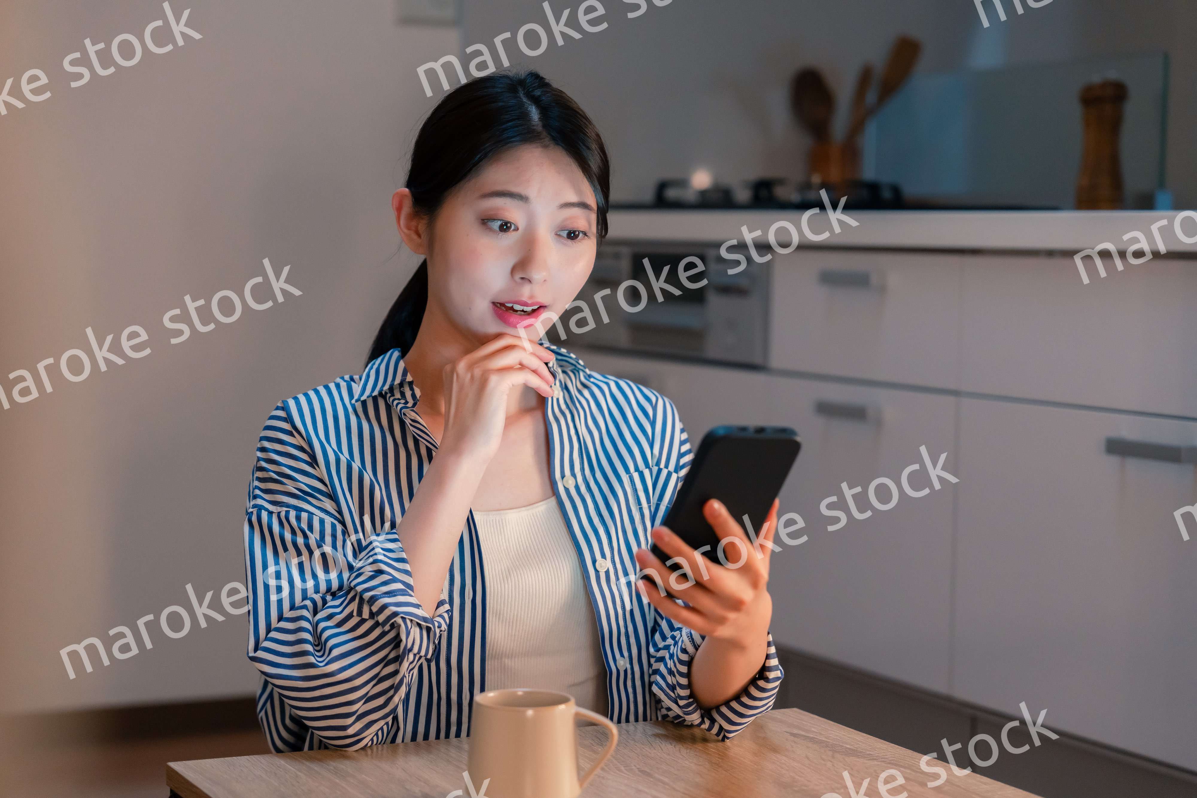 夜遅くに笑顔でスマホを使う若い女性