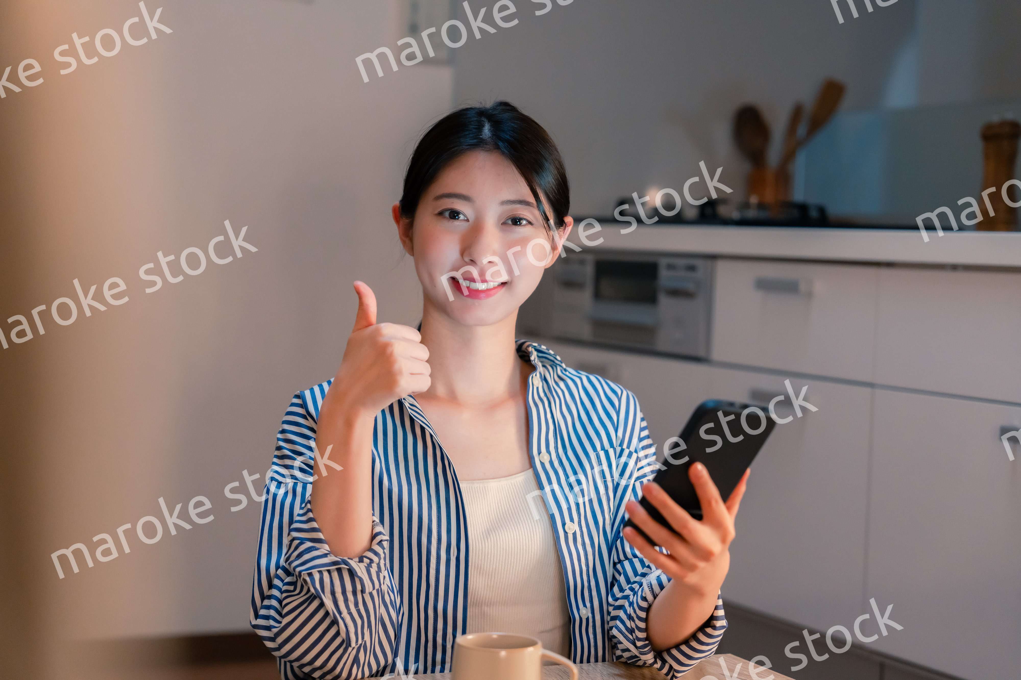 夜遅くに笑顔でスマホを使う若い女性