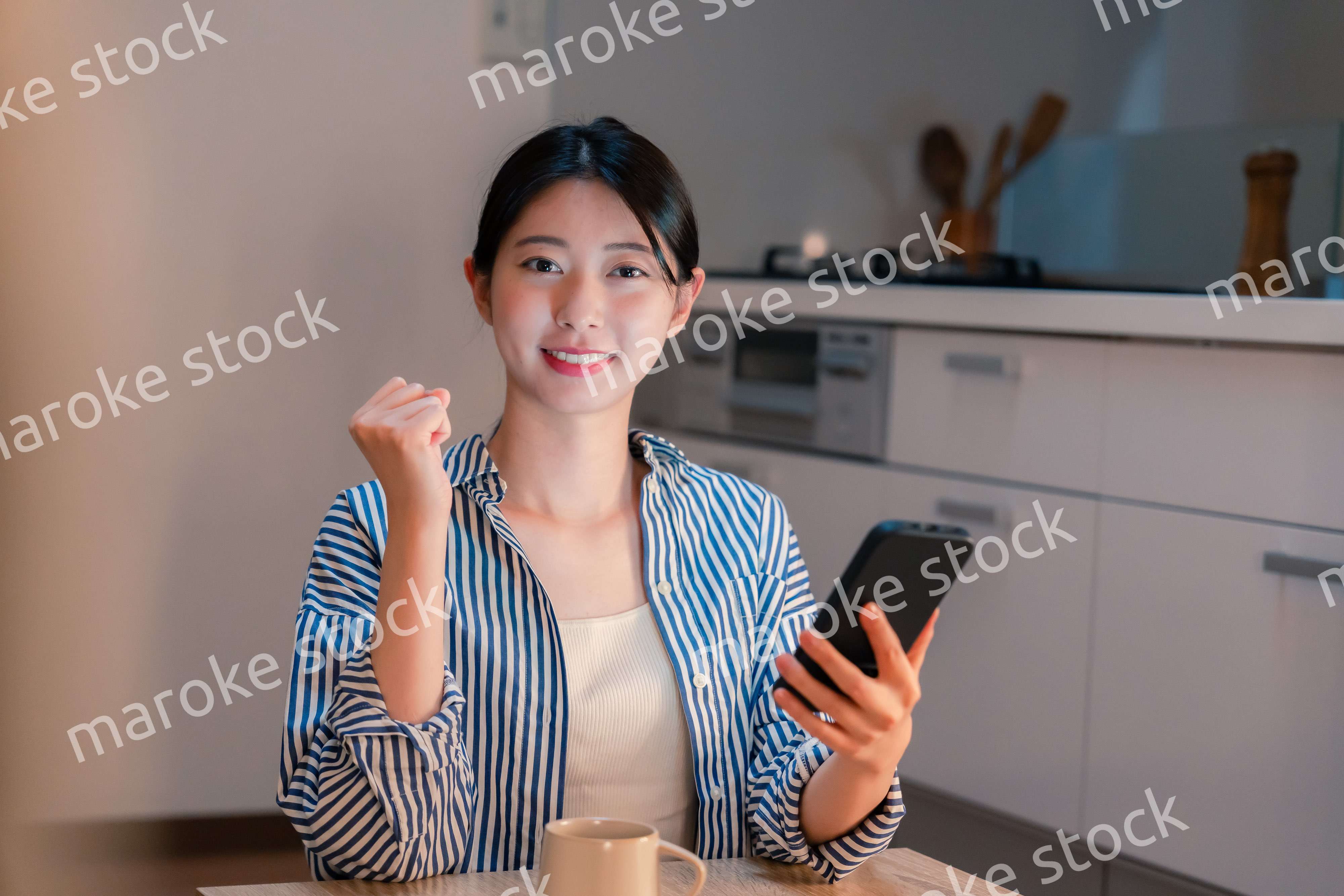 夜遅くに笑顔でスマホを使う若い女性