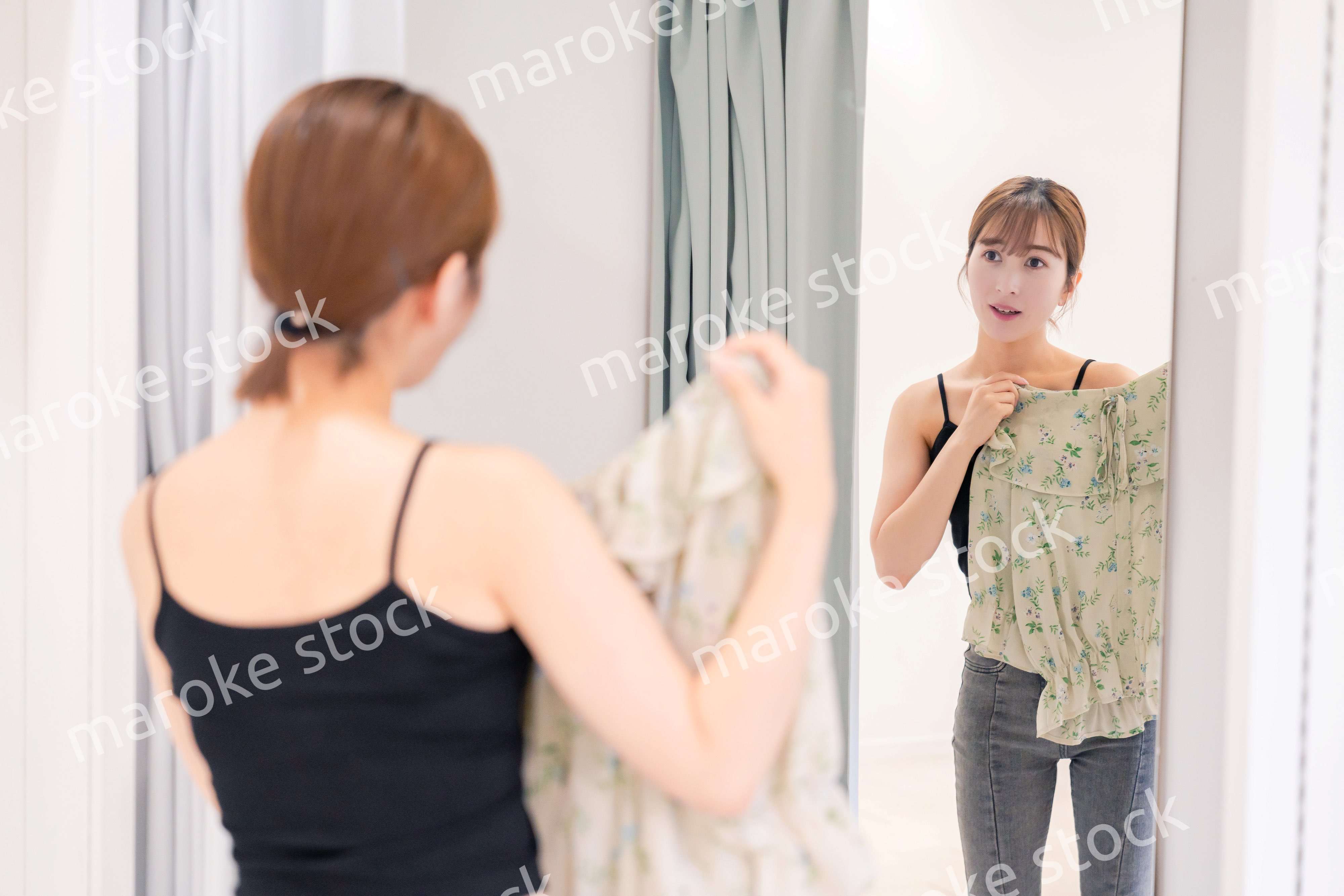 試着室で服の試着をする若い女性