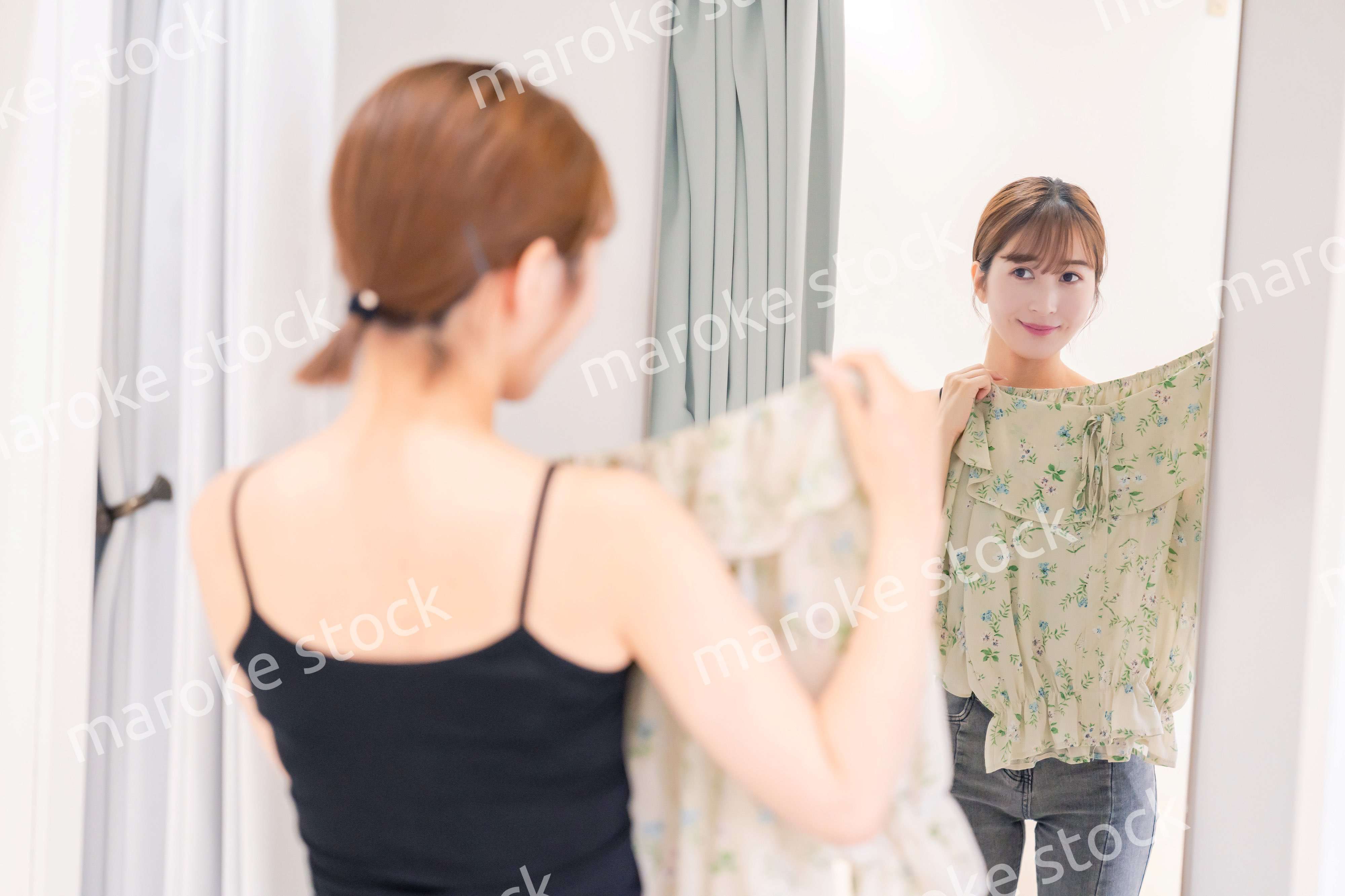 試着室で服の試着をする若い女性