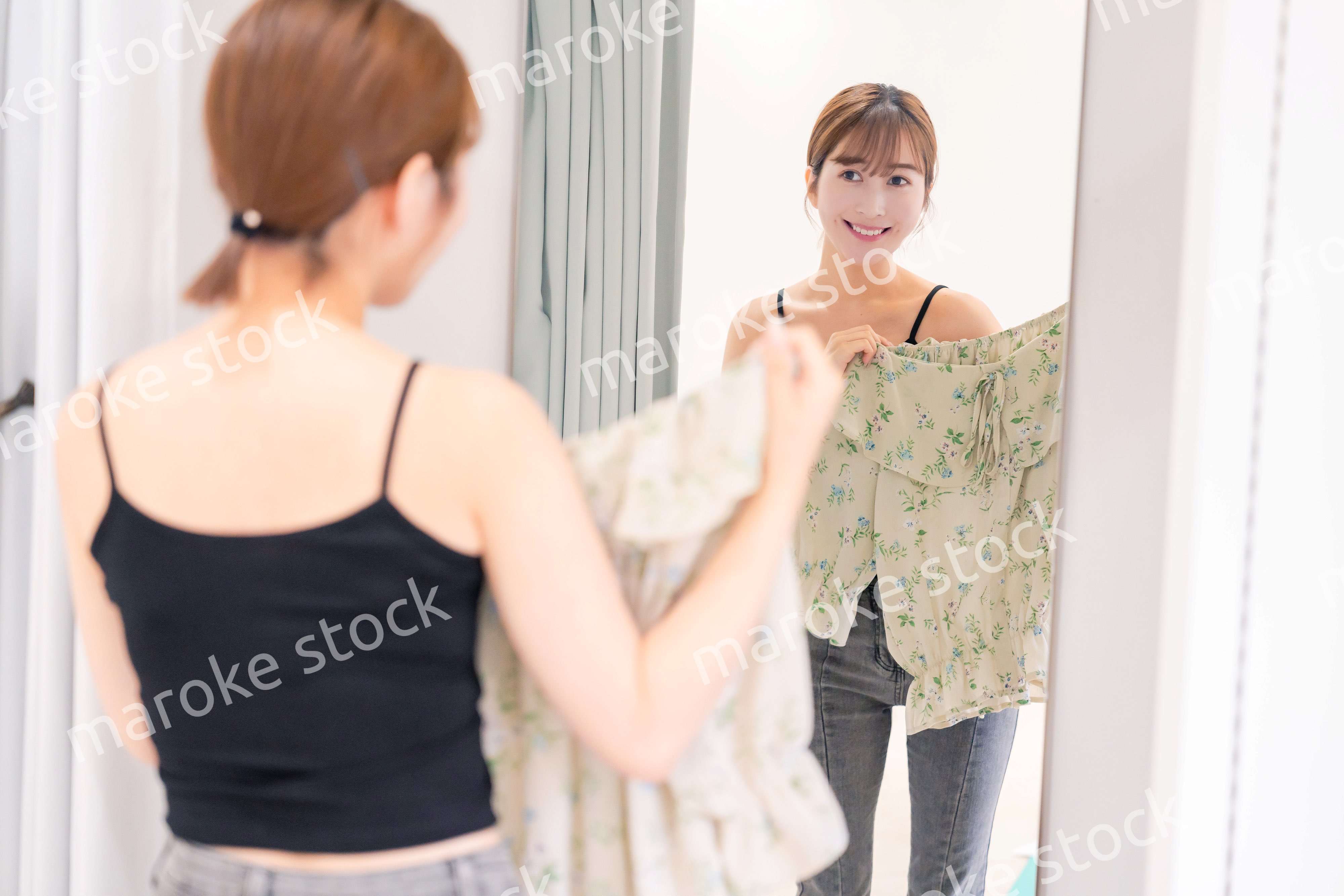 試着室で服の試着をする若い女性