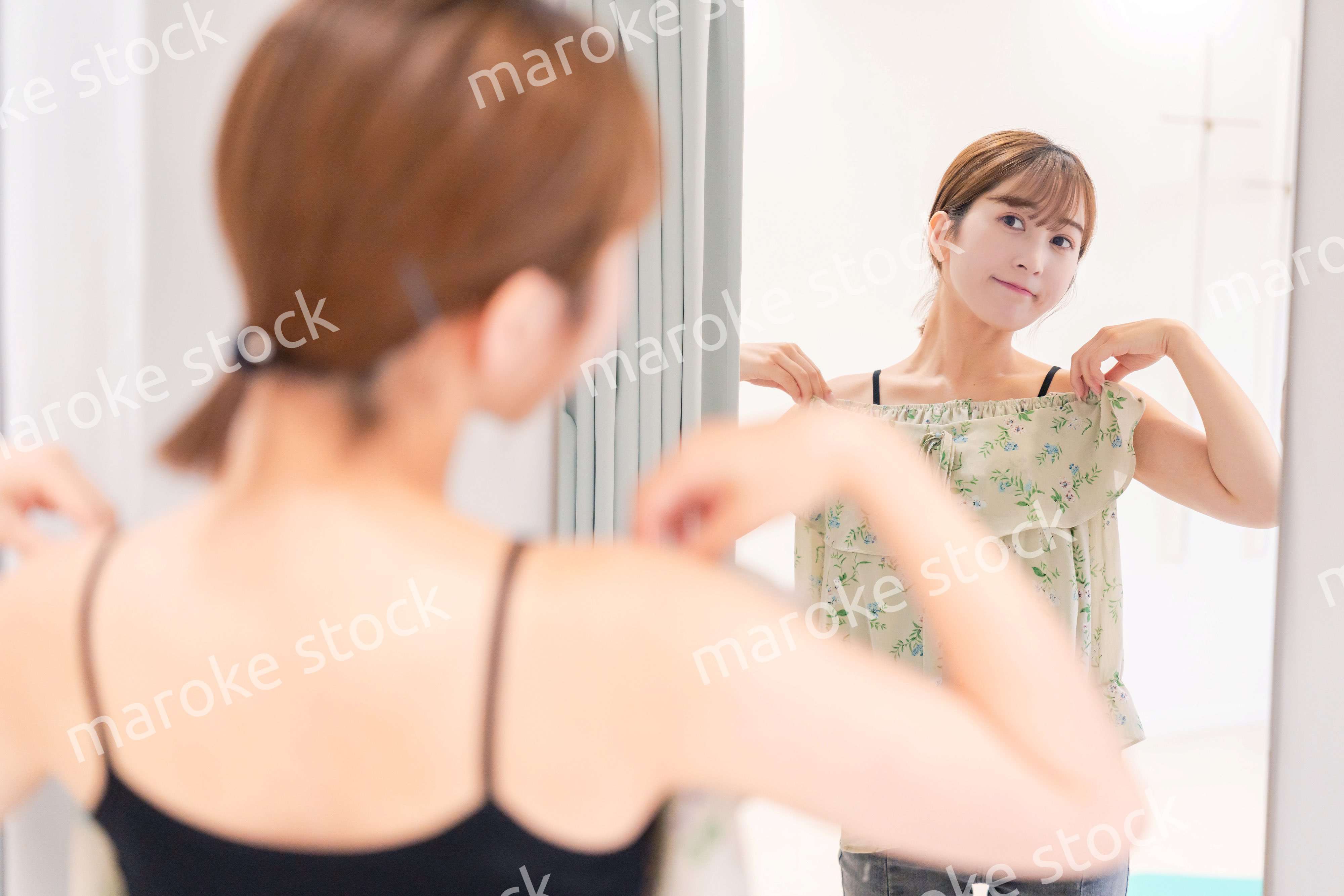 試着室で服の試着をする若い女性