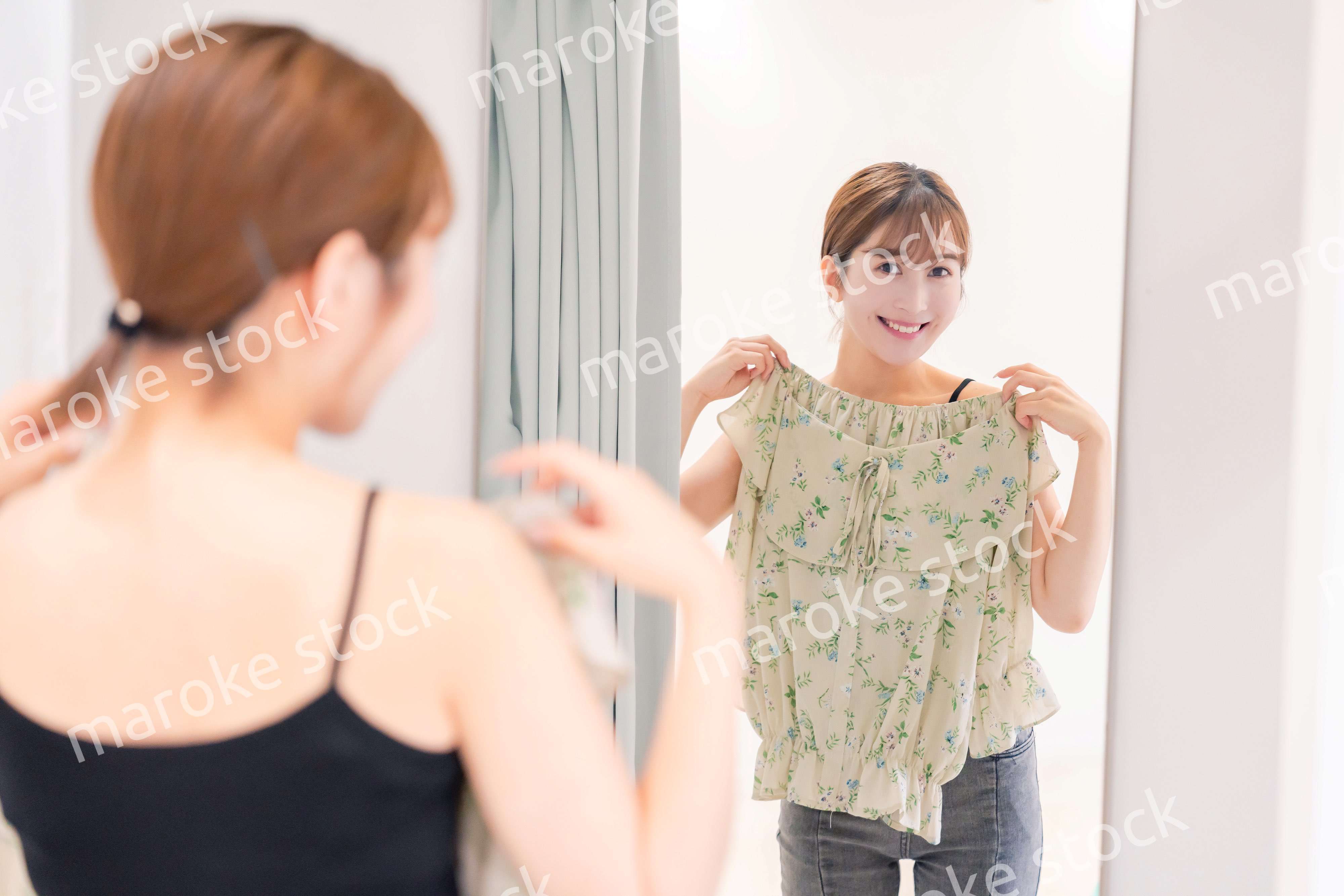 試着室で服の試着をする若い女性