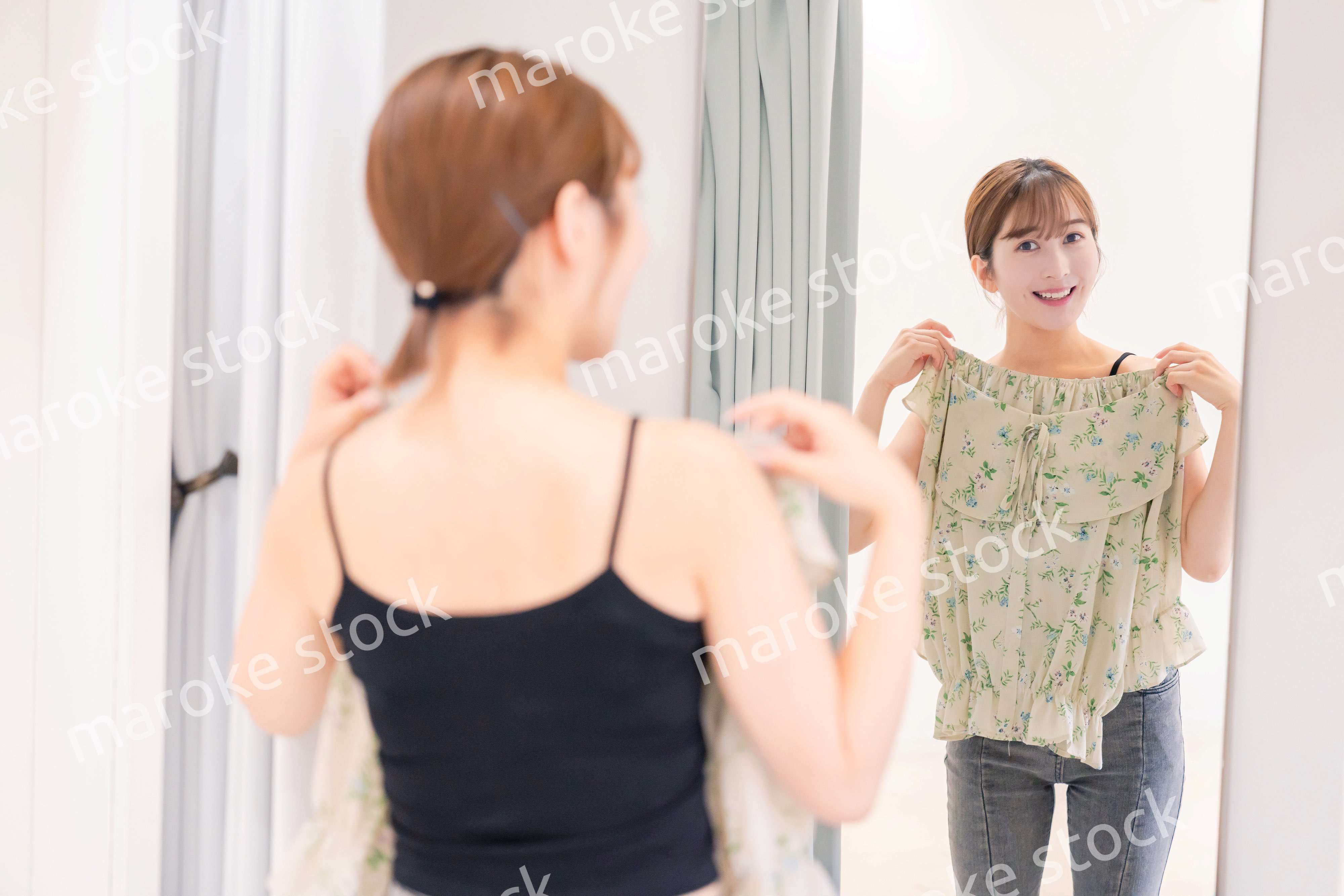 試着室で服の試着をする若い女性