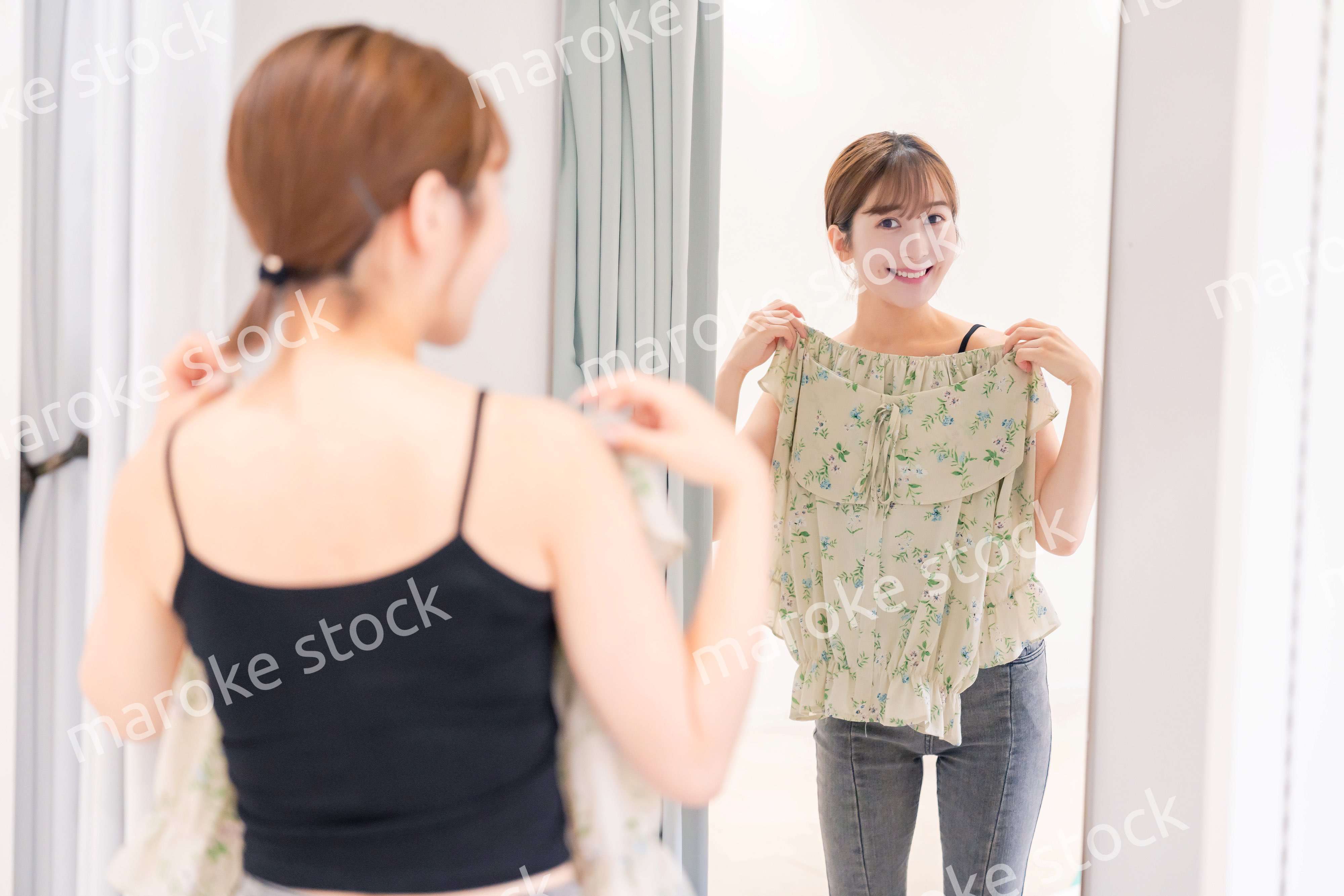 試着室で服の試着をする若い女性