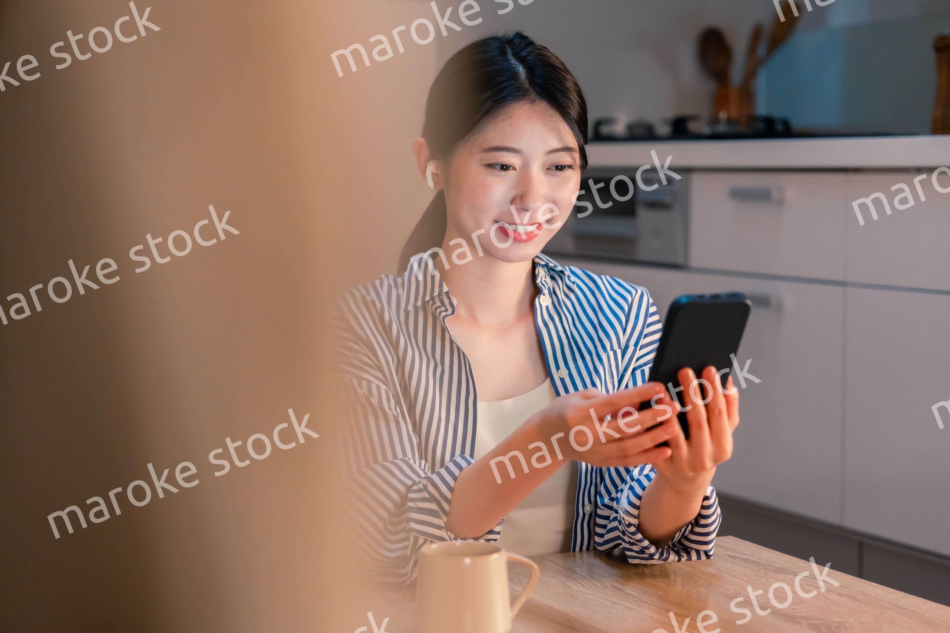 夜にスマホでコンテンツを楽しむ一人暮らしの女性