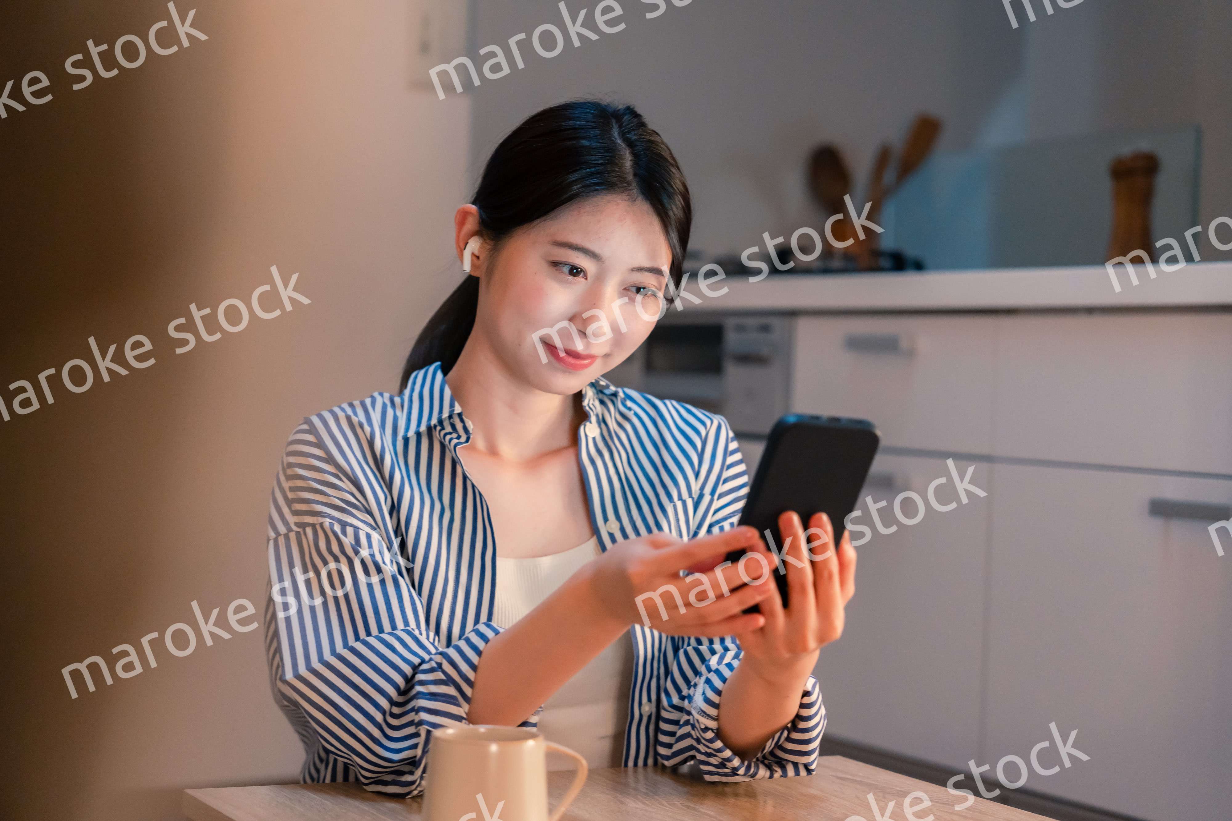 夜にスマホでコンテンツを楽しむ一人暮らしの女性