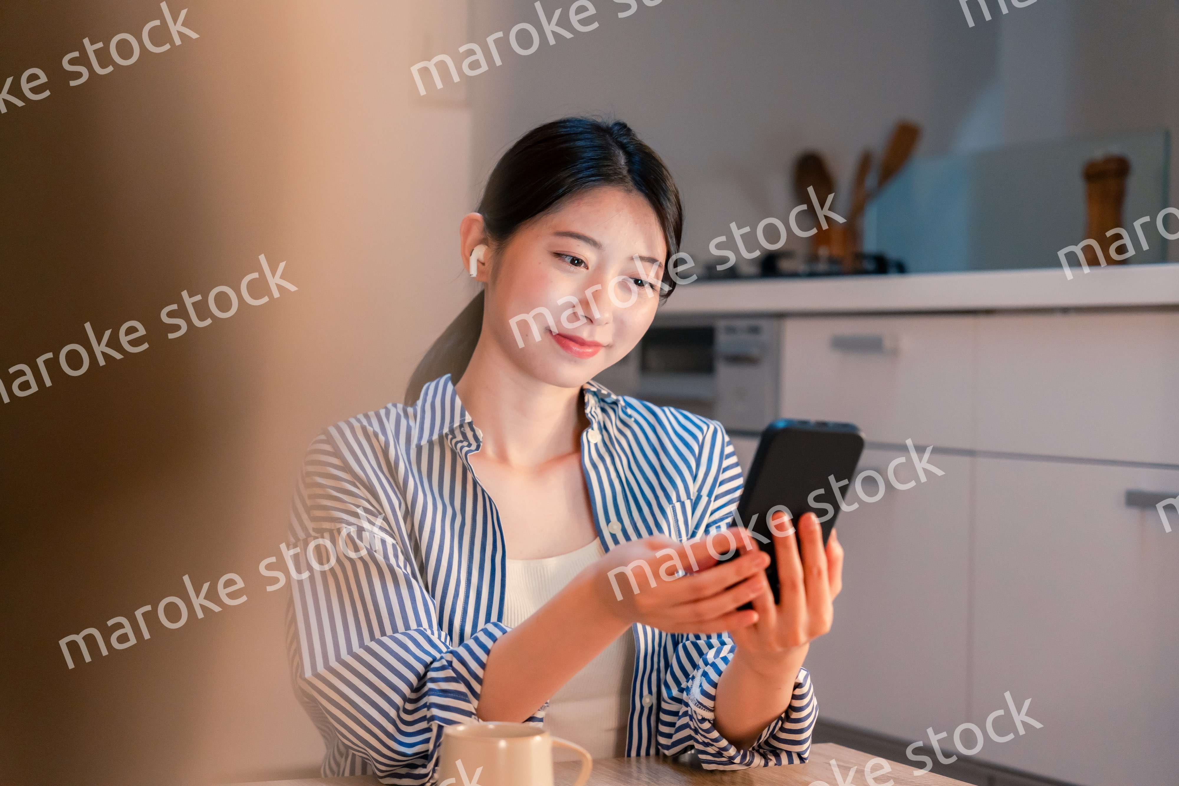 夜にスマホでコンテンツを楽しむ一人暮らしの女性