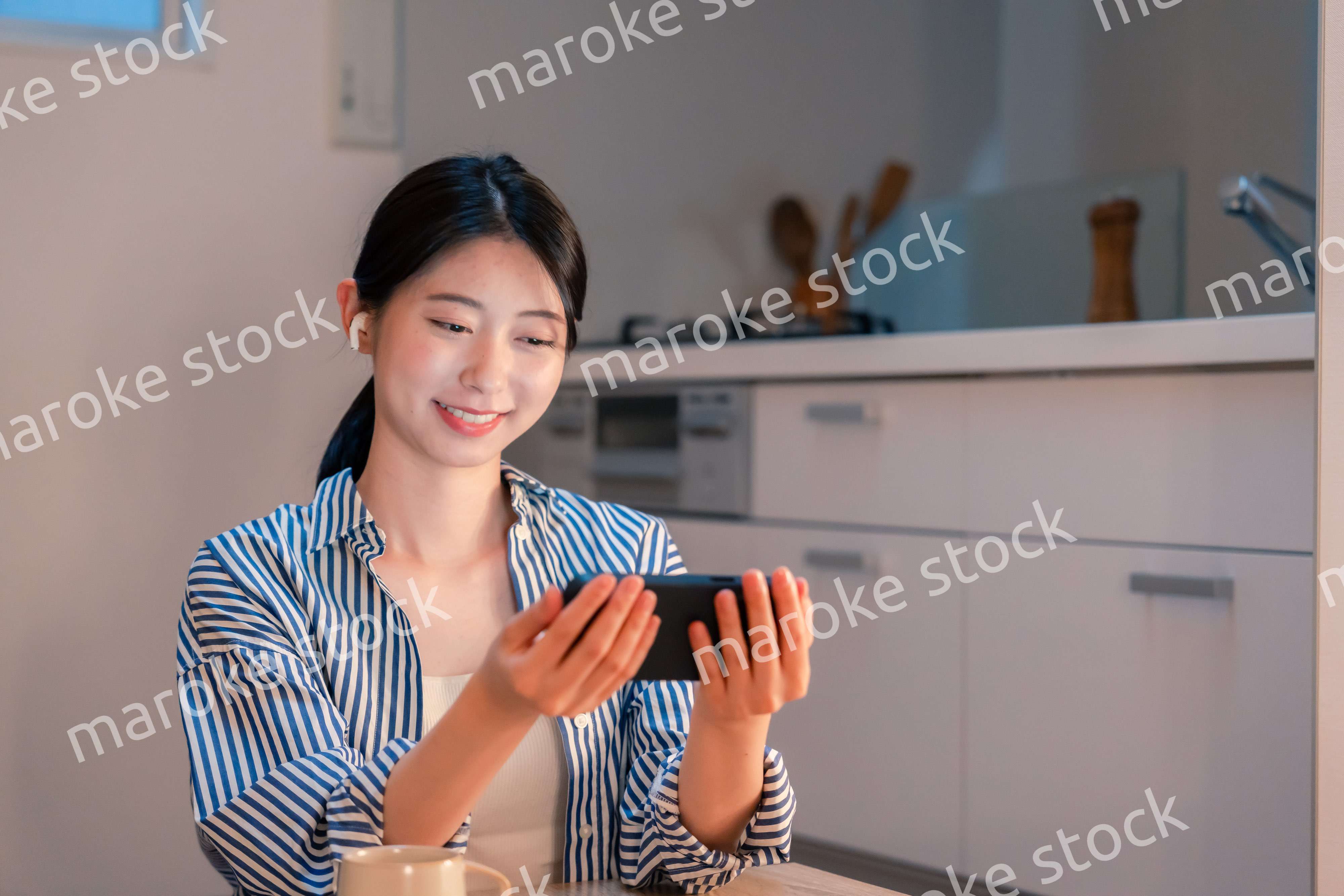 夜にスマホでコンテンツを楽しむ一人暮らしの女性