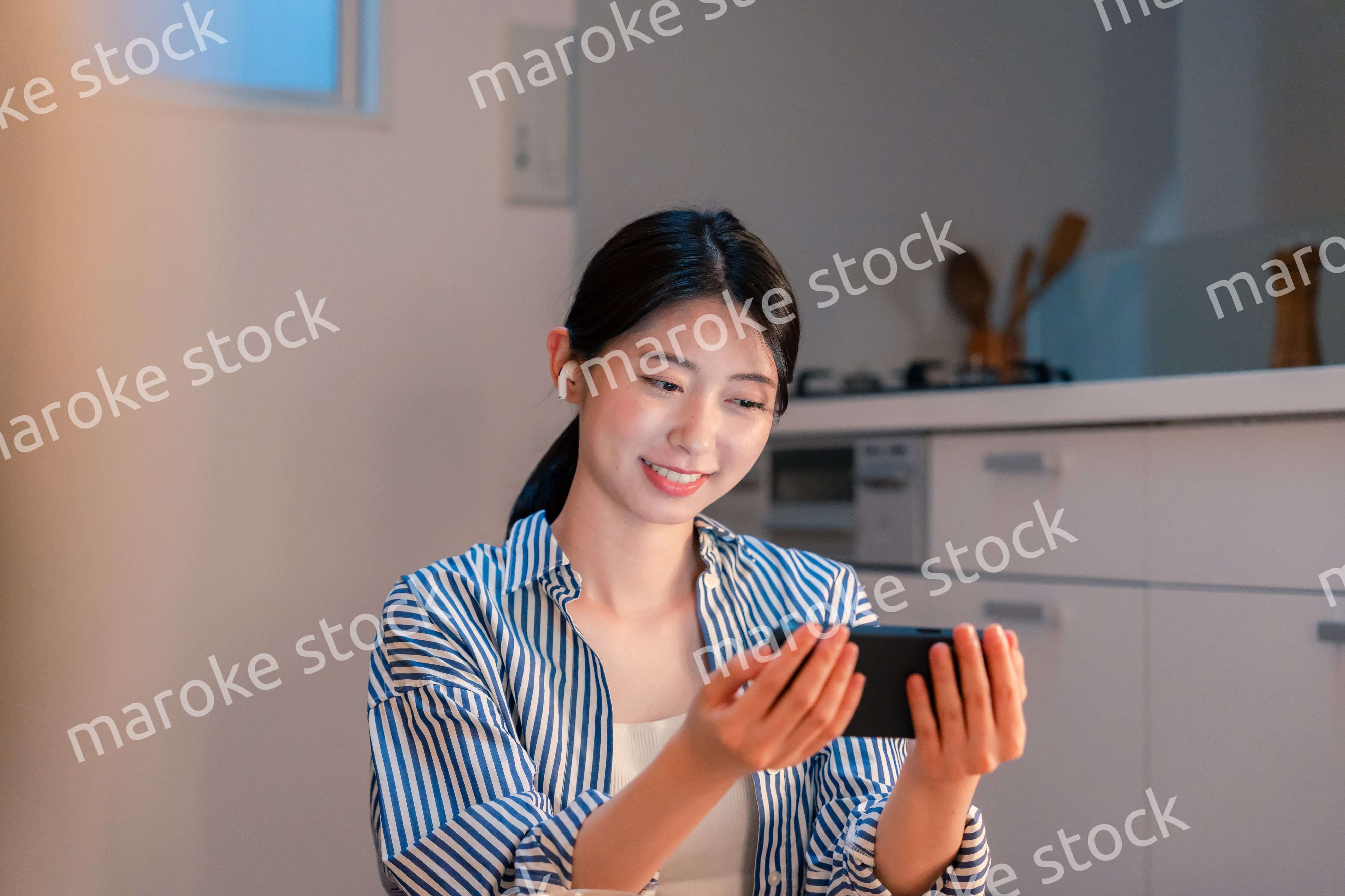 夜にスマホでコンテンツを楽しむ一人暮らしの女性