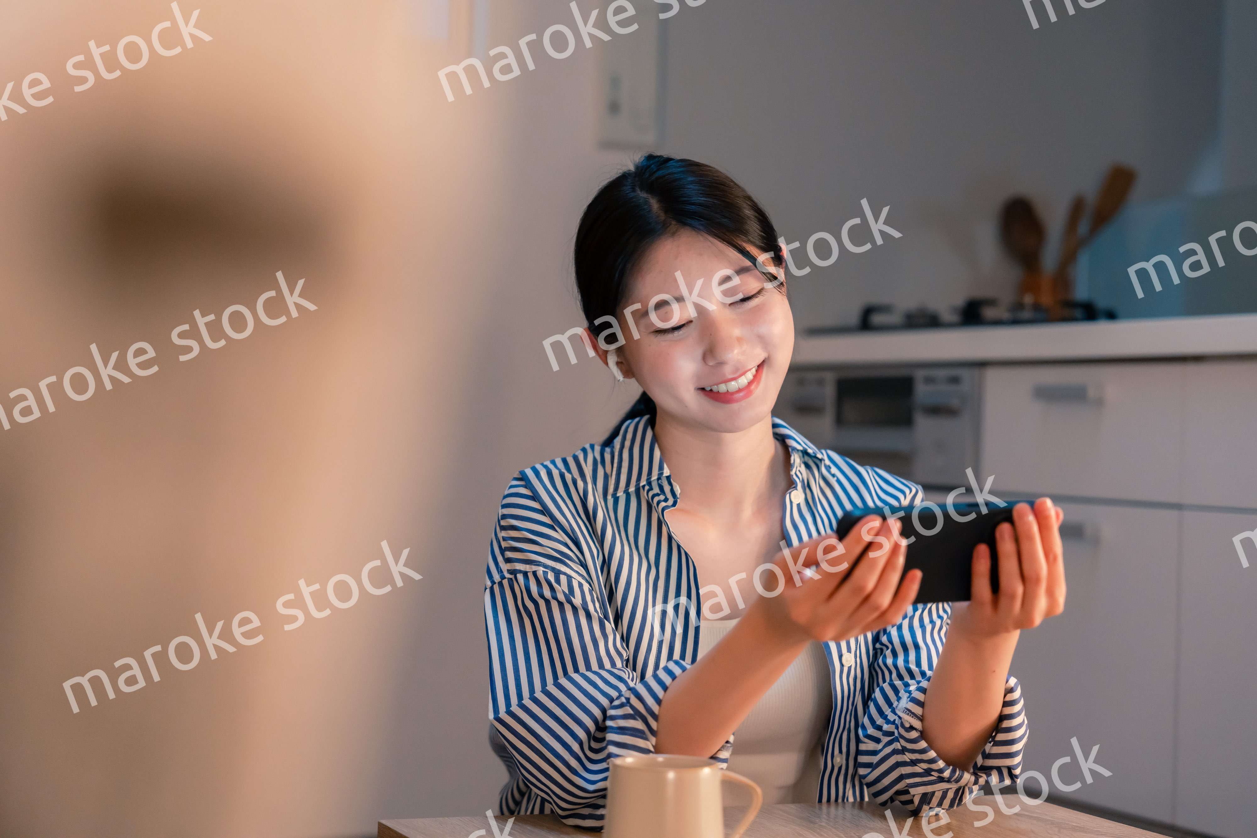 夜にスマホでコンテンツを楽しむ一人暮らしの女性